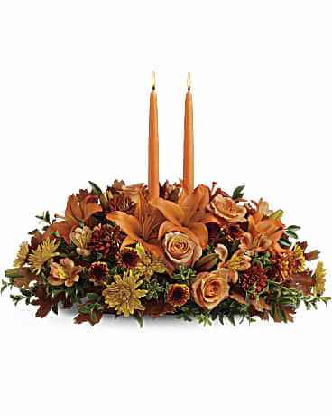 Gathering Centerpiece Gathering Centerpiece - Fall flowers include orange roses, orange asiatic lilies, dark orange alstroemeria, bronze button mums, yellow cushion mums, rust cushion mums, green oregonia and green huckleberry. Accented with oak leaves and two orange taper candles.