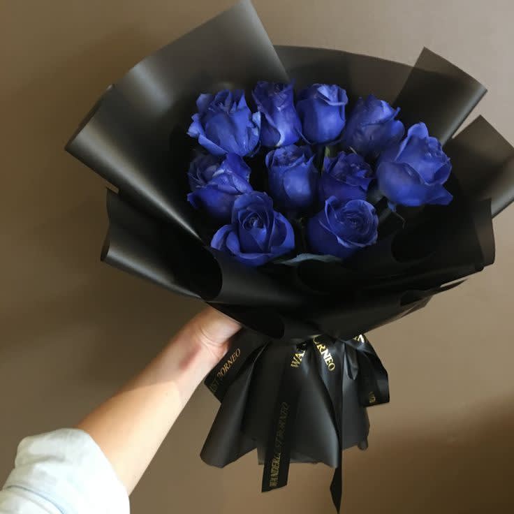 Blue Haze - A hand-tied bouquet featuring 12 stunning blue roses, elegantly wrapped in luxurious floral paper for a sophisticated and timeless presentation. 