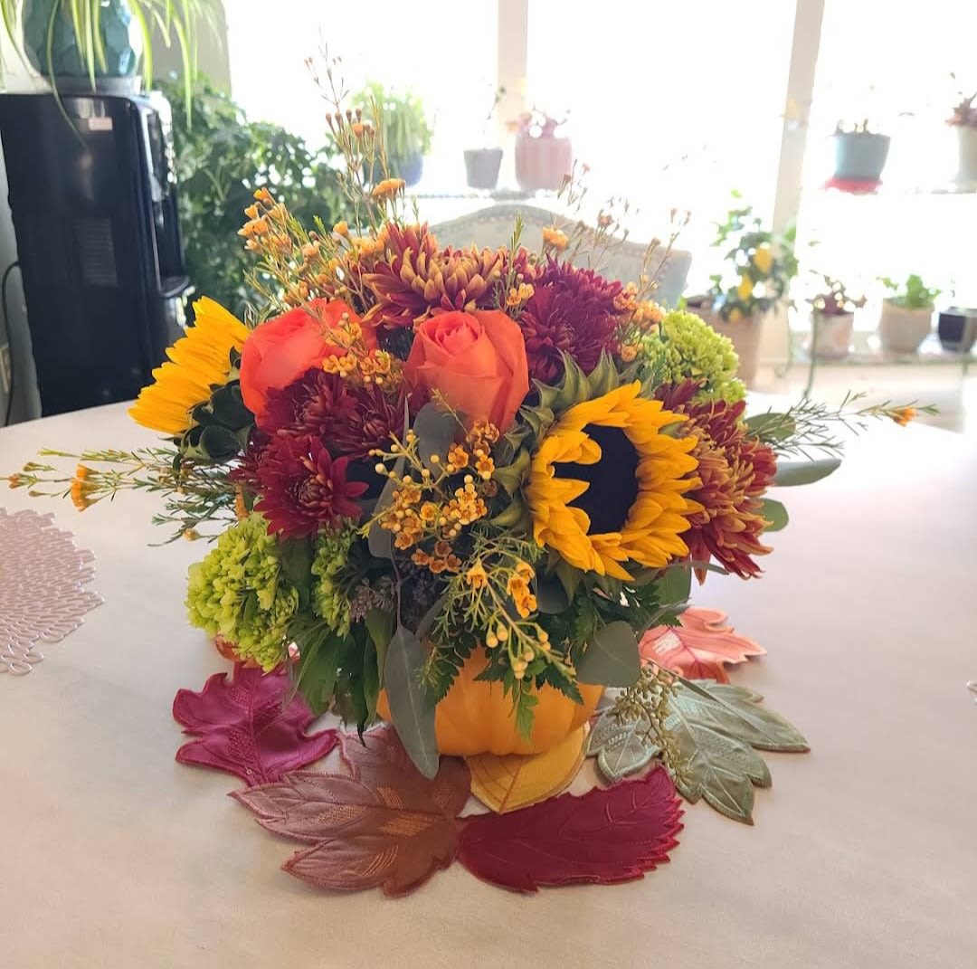 Pumpkin Spice and Everything Nice - A delightful seasonal arrangement of fresh flowers and fall accents, masterfully arranged in a decorative keepsake pumpkin. 