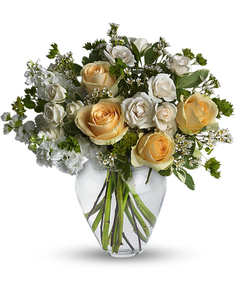 Celestial Love - Peaceful and pure. This pretty arrangement of white and light colors will let anyone know they are in your thoughts. Fresh flowers such as peach roses, cr&amp;egrave;me spray roses, white stock, waxflower and more are gathered in a beautiful clear vase.Approximately 16&quot; W x 16&quot; H