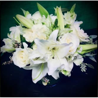 Isle of White by Donya's Florals - The Isle of White Centerpiece is all dressed in white but overcompensates with textural richness and lush greenery. Rich and textural, nothing boring about this oriental lily centerpience, making it suitable for any recipient or occasion.