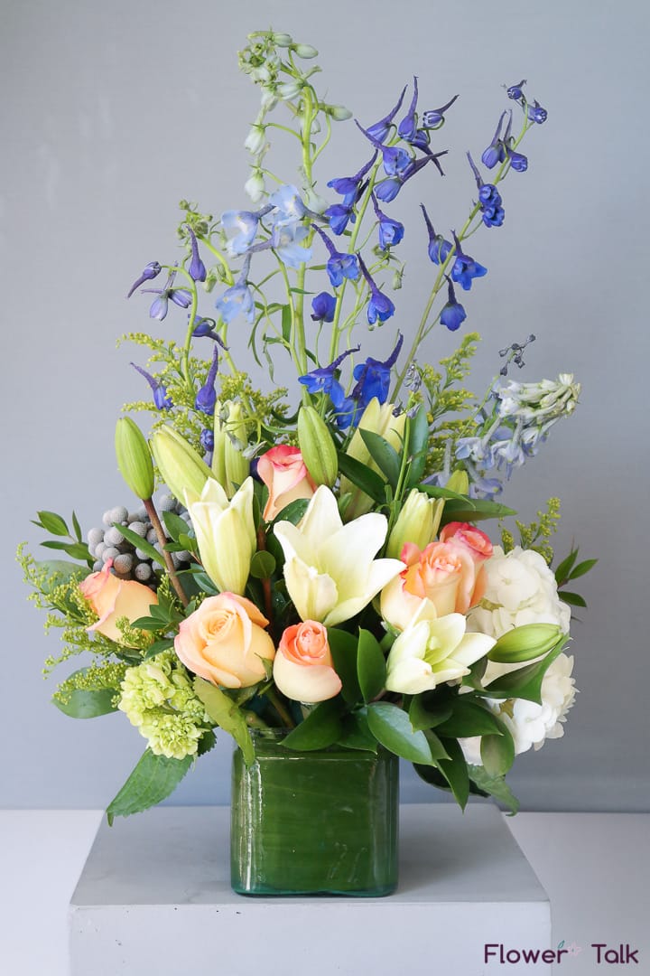 Flower Talk's Seaside Bouquet Flower Talk's Seaside Bouquet - This refreshing bouquet includes delphiniums, lilies, spray roses and hydrangeas. Like a breezy seaside, this bouquet brings a relaxing vibe to the room.