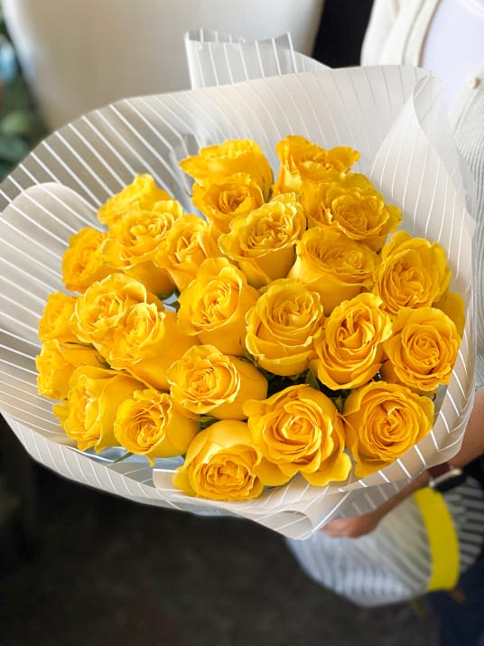 Yellow Radiance - Inspired by the warmth of a golden sunrise, the Yellow Radiance bouquet features 18 vibrant yellow roses, beautifully wrapped in rustic paper. This cheerful arrangement is perfect for spreading joy and brightness, just like the lyrics of a classic song that reminds us of sunny days.
