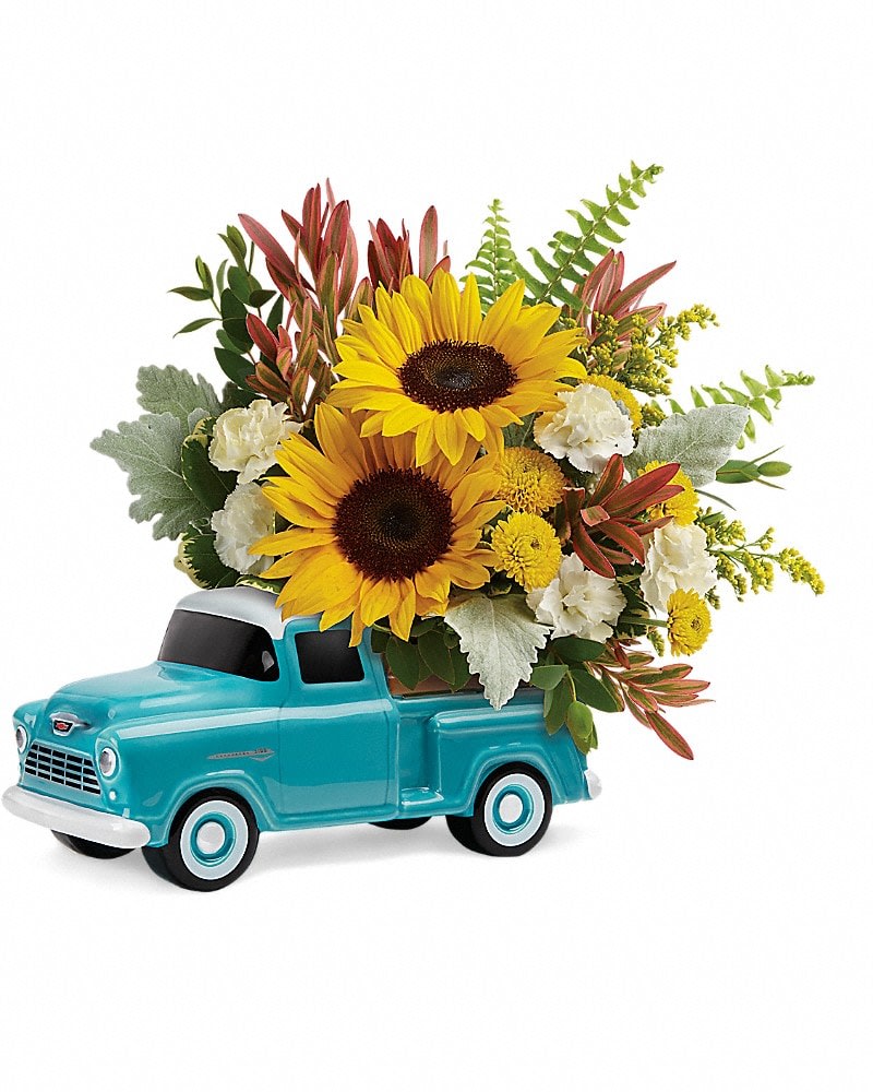 Teleflora's Chevy Pickup Bouquet - Talk about a dream machine! Piled high with cheerful sunflowers, this hand-painted, hand-glazed Chevy pickup is a Father's Day dream come true. It's one of the ways we're commemorating the 100th Anniversary of Chevy Trucks! This bouquet includes small yellow sunflowers, miniature white carnations, yellow button spray chrysanthemums, red leucadendron, solidago, sword fern, dusty miller, variegated pittosporum, and parvifolia eucalyptus. Delivered in a Chevy Pickup Keepsake.