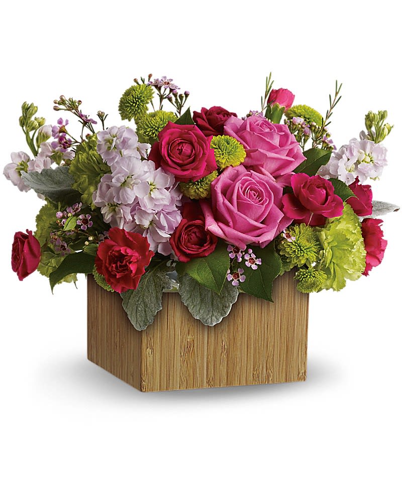 Teleflora's Garden Delights - Put a smile on her face and a spring in her step with this delightful little garden bouquet. Presented in a chic bamboo box, its happy hot pinks and lovely lime greens give a colorful pick-me-up! Bright pink roses and carnations are contrasted with green carnations and button spray chrysanthemums, light pink stock and delicate lavender waxflower -fresh greens include lemon leaves and soft dusty miller. Delivered in a sculptural natural bamboo vase to give it a contemporary look.