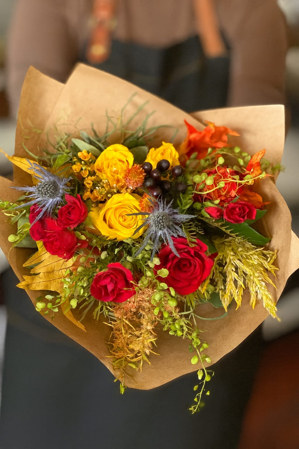 Sweater Weather - Seasonal Fall Bouquet  - Sweater Weather Bouquet – Cozy Autumn Floral Arrangement  Celebrate the beauty of fall with our Sweater Weather Bouquet, a warm and inviting arrangement designed to capture the essence of the season. Bursting with rich autumn colors, this bouquet features vibrant red and golden yellow roses, rustic seasonal blooms, textured greenery, and unique accents that bring depth and charm. Perfect for adding a touch of fall décor to your home, gifting to a loved one, or creating a cozy seasonal centerpiece, the Sweater Weather Bouquet embodies everything we love about crisp autumn days. Handcrafted with care, it’s a thoughtful way to welcome the season in style.