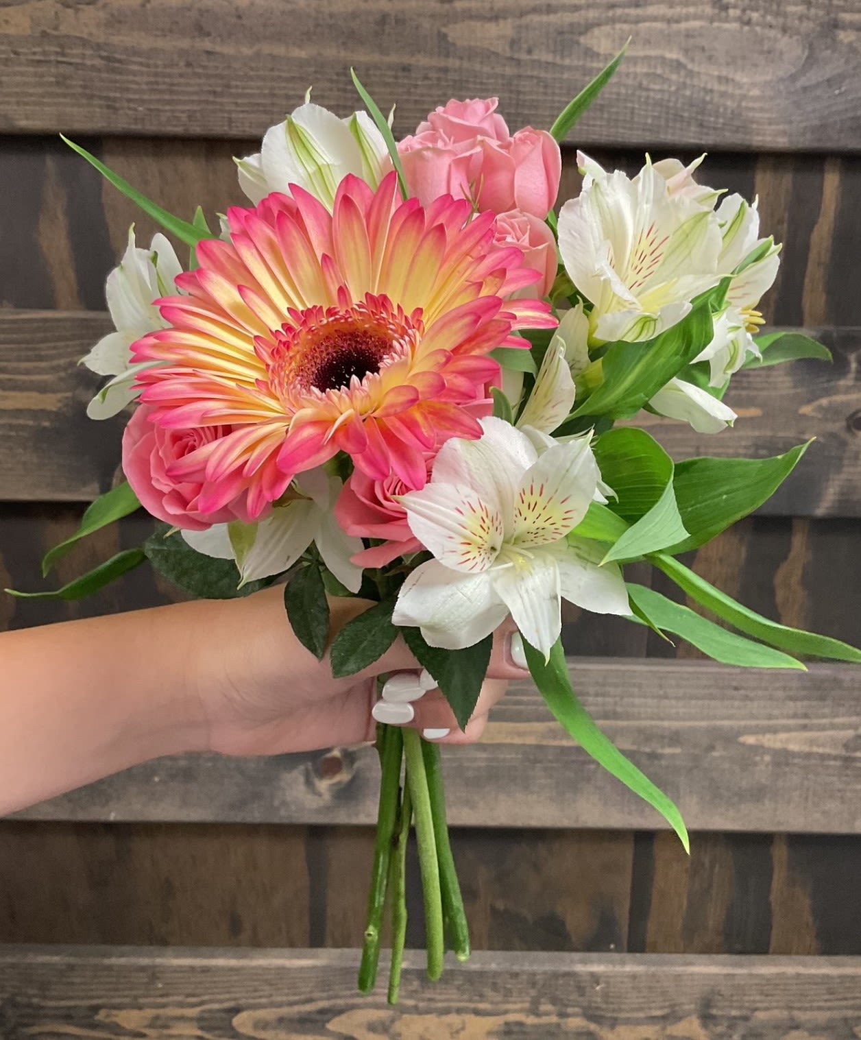 Valencia - A pastel collection of blooms in a petite nosegay bouquet~ perfect for holding in photos!  Pick up dates for homecoming are Saturday, September 27th and Saturday, October 4th. Please call if you need to order this for a different event.