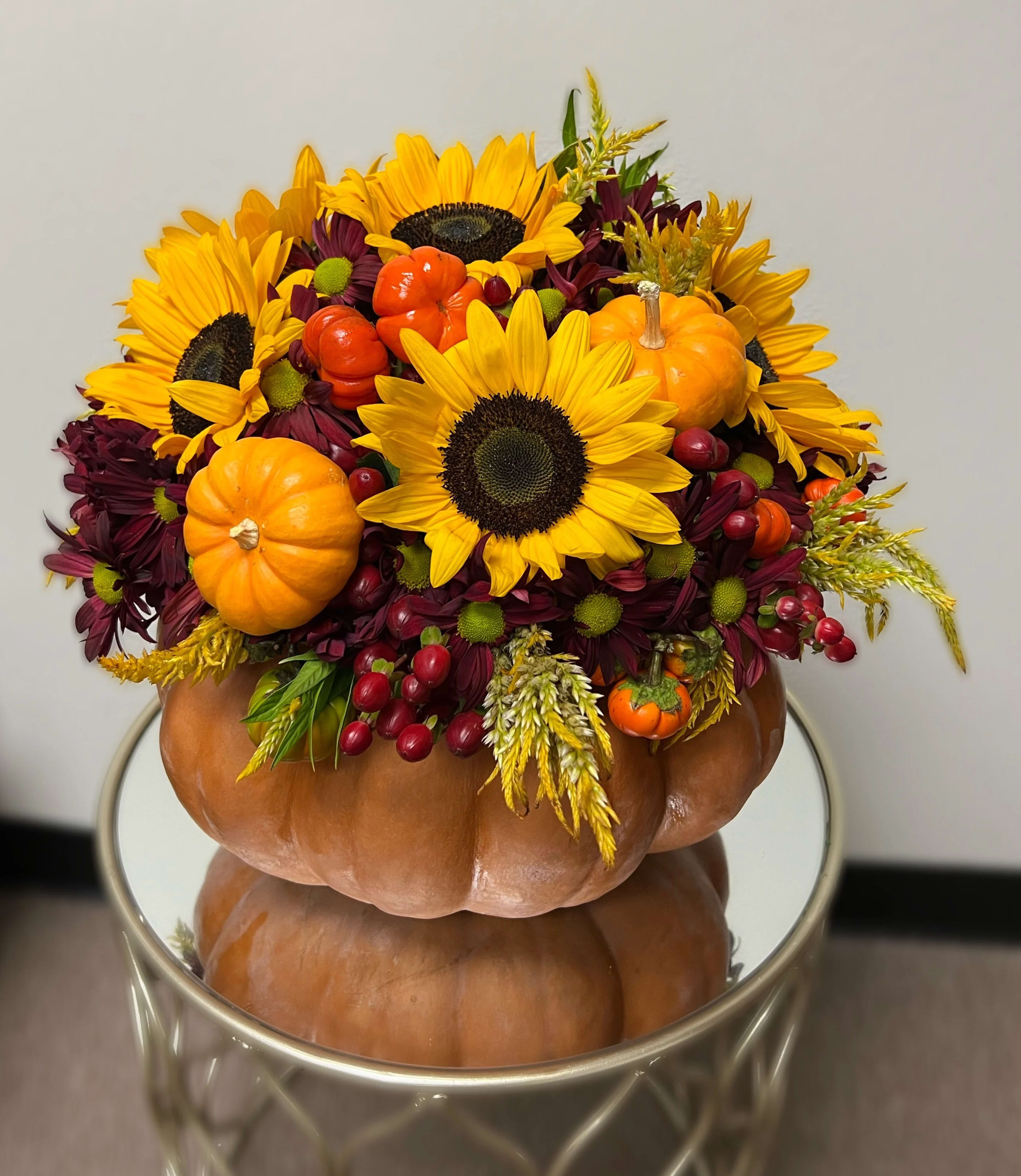 Pumpkin Signature Arrangement - Embrace the spirit of autumn with our Pumpkin Signature Arrangement, a truly unique and festive centerpiece from L'amour Toujours Flower Boutique. As the leading Las Vegas florist, we've captured the essence of the season in this charming and rustic arrangement. Nestled within a fresh, hand-hollowed pumpkin, this design features a rich tapestry of fall blooms, including fiery orange roses, deep red dahlias, and cheerful sunflowers. The vibrant colors are beautifully complemented by delicate gold-hued accents and lush seasonal foliage, creating a warm and inviting display.    This arrangement is a perfect choice for your Thanksgiving table, a fall wedding, or a memorable housewarming gift. At L'amour Toujours Flower Boutique, we are renowned for our creative and luxurious designs, ensuring every piece is a work of art. When you choose us for your Flower Delivery in Las Vegas, NV, you're not just sending flowers; you're sending a one-of-a-kind experience.    Our reputation as a trusted Las Vegas florist means you can count on us for impeccable quality and service. This unique pumpkin centerpiece is a testament to our dedication to creating stunning and unforgettable arrangements. For those searching for &quot;Flower Delivery in Las Vegas, NV&quot; to add a touch of fall charm to any celebration, the Pumpkin Signature Arrangement is a truly special selection that will impress all who see it.