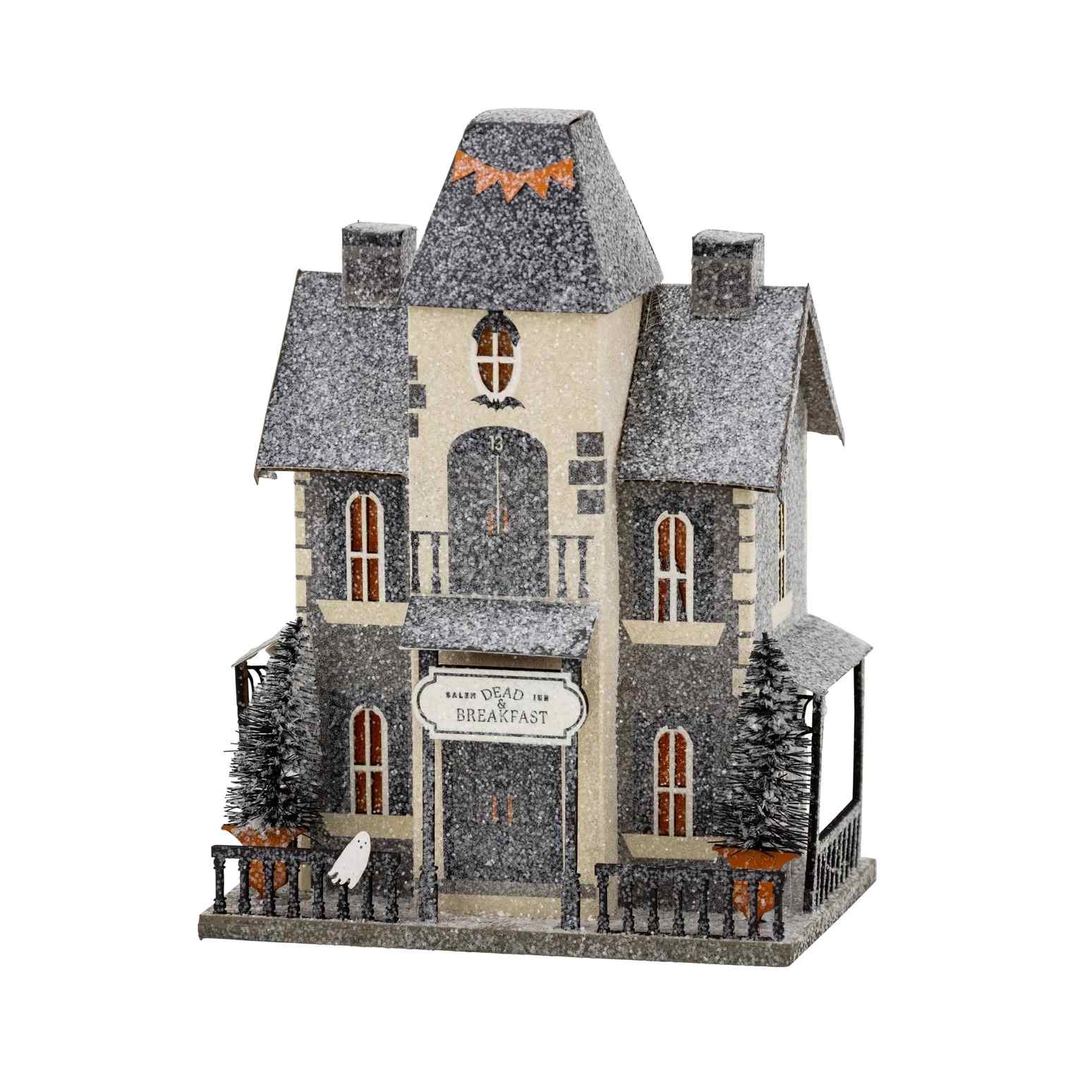 Halloween Dead & Breakfast Halloween Dead & Breakfast - Add a touch of spooky charm to your Halloween village with our "Dead & Breakfast" haunted house! This wickedly fun decoration features ghostly guests, eerie details, and a playfully macabre design that's perfect for your Halloween party setup. Create the ultimate spooky scene that will have everyone dying to stay the night at this haunted hotspot! • House is 5.75 wide x 4" deep x 7.75" tall • includes battery powered light inside