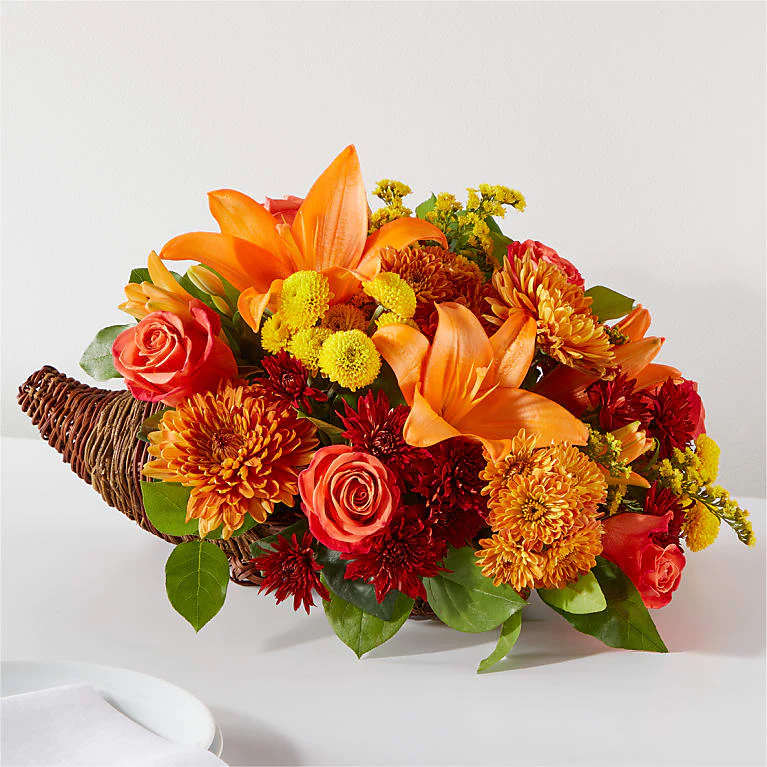 Cornucopia Arrangement - Embrace the spirit of Thanksgiving with a centerpiece that’s bursting with bountiful blooms. Order Online. Let us do the hard work! We’ll design you a custom arrangement using a mix of the freshest fall blooms and textures available.  Flowers shown in the picture are for example only and not a guarantee of the type of flowers used.  Place your Order Online Monday to Saturday before 1:00 p.m. (E.T.) for same-day delivery.  “Orders received after hours will be delivered the next business day”. Check our coverage area.  Occasionally, substitutions of flowers and/or containers happen due to weather, seasonality, and market conditions which may affect availability. If this is the case with the gift you’ve selected, we will ensure that the style, theme, and color scheme of your arrangement are preserved and will only substitute items of equal value or higher value.  CARE INSTRUCTIONS Keep the flower arrangement hydrated with natural water and change the water every two days. Do not spray any cleaning product on the flower arrangement. Do not place heavy objects directly on the flower arrangement. Keep flower arrangements out of direct sunlight and extreme heat.