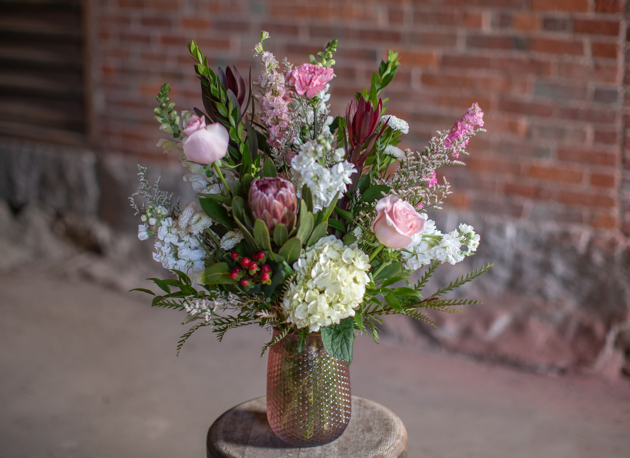 Passionate Protea - Take home something exotic! Very unique protea flowers are just that, tropical and outside the box. Something you don't see everyday. Pinks and whites with rich reds speaks a passionate language. The focal flowers of protea and hydrangea are sure to impress any recipient. Please note, these are exotic and may not be in stock sometimes we require 24-48 hours to source protea flowers. We do our best to mark things as out of stock when sold out of a specialty. 
