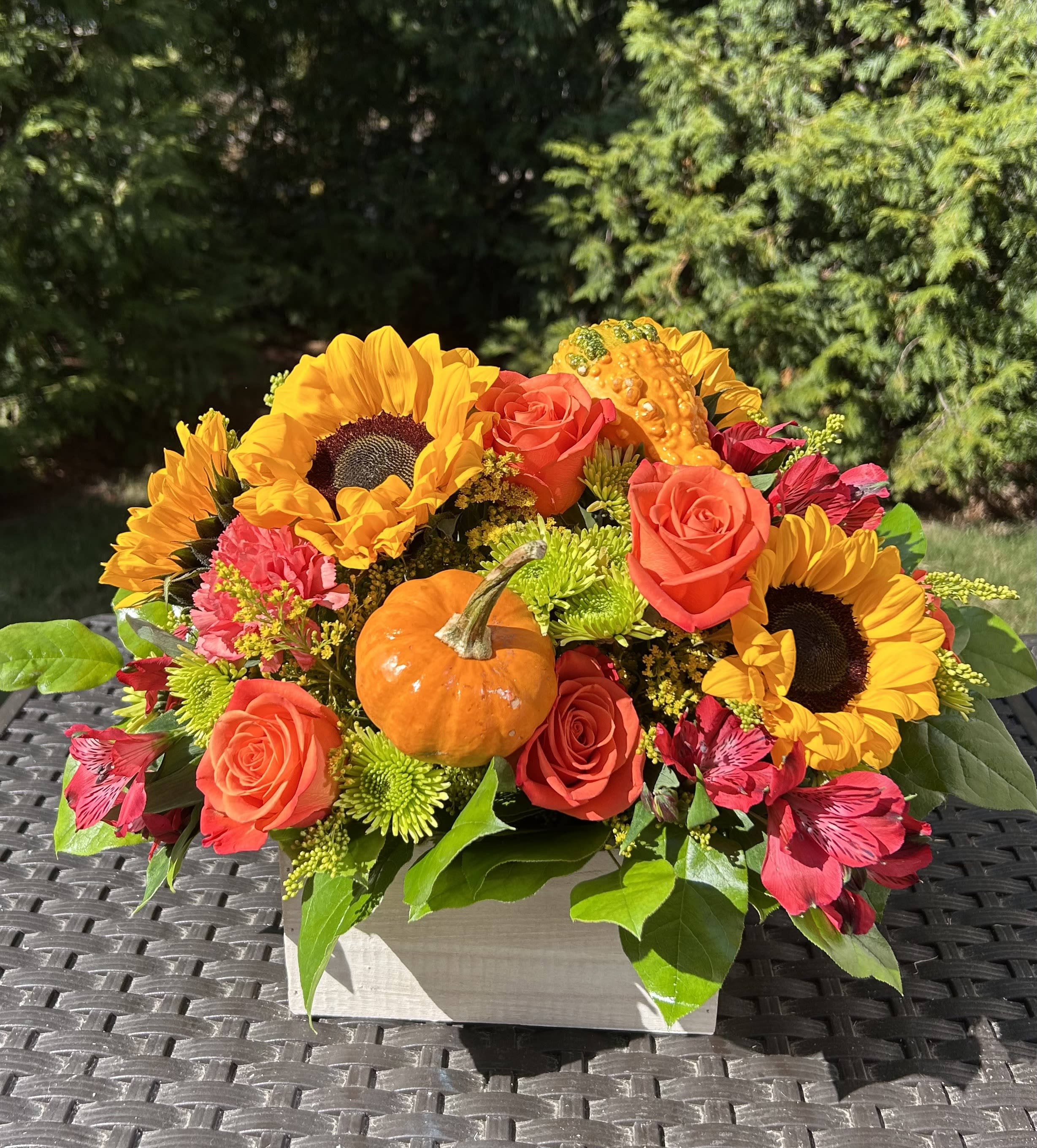Sunny Autumn Wooden Box - Celebrate the harvest season! This vibrant arrangement captures all the magic of autumn with radiant sunflowers, warm orange roses, and a festive pumpkin accent. Presented in an elegant white wooden box, it's the perfect centerpiece to welcome the season.  WHITEWASHED WOODEN BOX All Occasion  Place your Order Online Monday to Saturday before 1:00 p.m. (E.T.) for same-day delivery. “Orders received after hours will be delivered the next business day”. Check our coverage area.  Occasionally, flowers and/or container substitutions happen due to weather, seasonality, and market conditions, which may affect availability. If this is the case with the gift you’ve selected, we will ensure that your arrangement's style, theme, and color scheme are preserved and will only substitute items of equal value or higher value.  CARE INSTRUCTIONS Gently mist the arrangement with natural water every other day. Do not spray any cleaning product on the flower arrangement. Do not place heavy objects directly on the flower arrangement. Keep them out of direct sunlight and extreme heat. 