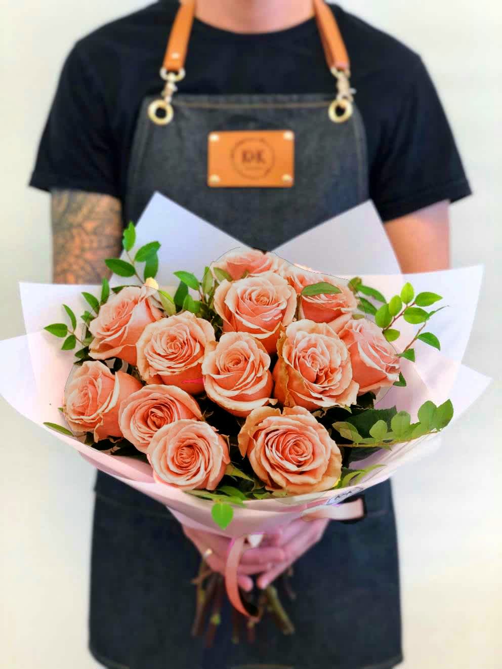 PROMO Dozen Peach Roses Bouquet - Dozen Peach Roses with greenery and decorative wrapping paper. All bouquets come without a vase. You can choose a vase in the add-on section.