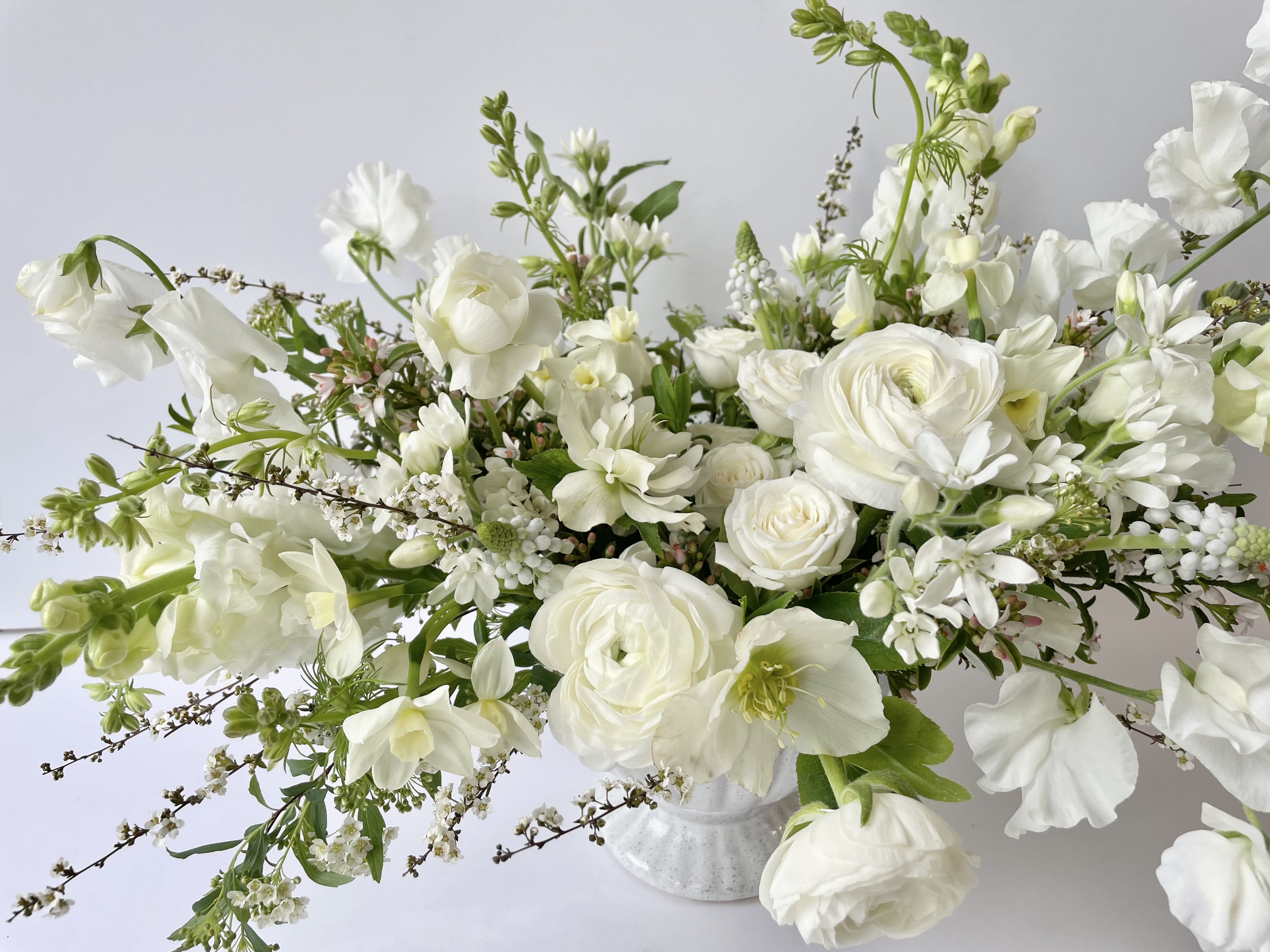&quot;Sending Sympathy&quot; Arrangement *DELUXE SIZE PICTURED* - **Pictured is the Deluxe size**  This is our standard, front-facing style arrangement in a beautiful all-white color palette. Arranged in lovely white ceramic, customers send this classic palette out for a wide range of occasions including, but not limited to, sending sympathies.   Concerning Seasonality: As a seasonal, locally-focused florist, we have different product to work with each week. Our focus is on creating a unique piece for each customer, with blooms that are fresh from local farms and growers. While the flower varieties and colors may vary, the quality and freshness will always be the best. It is an honor to have our customers' trust and confidence in our abilities and artistic eye.   Delivery Policy (**PLEASE READ**): Pick-ups at the studio are available after 2pm. Our daily delivery time frame is typically between 12- 3 PM. Please specify if you require a certain delivery time and we will do our best to accommodate it, or we will call you if we cannot.   We gently ask that those ordering flowers for someone else to please check first if the recipient of the flowers will be home during that time. Additionally, please be sure to include whether or not there is a gate we may need a code for. If there is no answer at the door, our delivery person will leave the flowers by the doorstep in a weather safe location. Completing your order acknowledges that you have read and understand our delivery policies. 