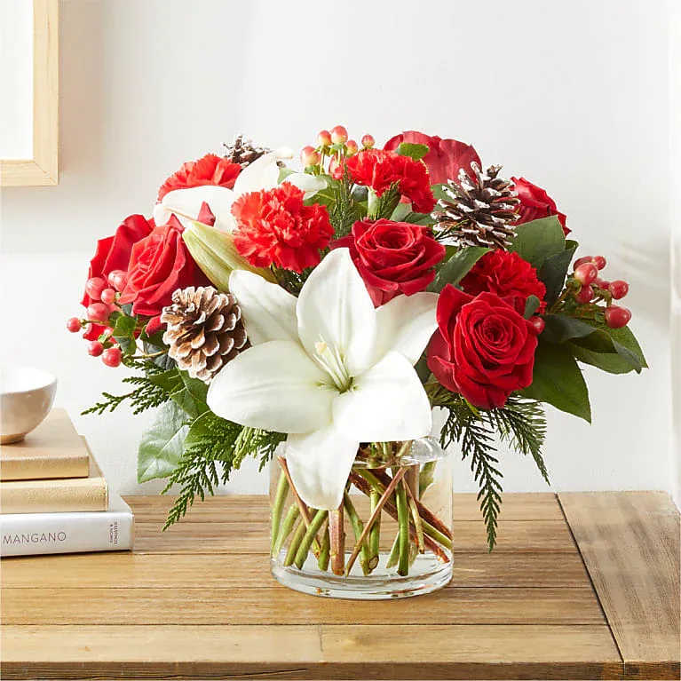 Feeling Festive Feeling Festive - Clear Glass Vase Bloom Details: Rose, Carnations, Hypericum Berry, Lily, Christmas Greens Place your Order Online Monday to Saturday before 1:00 p.m. (E.T.) for same-day delivery. “Orders received after hours will be delivered the next business day”. Check our coverage area. Occasionally, flowers and/or container substitutions happen due to weather, seasonality, and market conditions, which may affect availability. If this is the case with the gift you’ve selected, we will ensure that the style, theme, and color scheme of your arrangement are preserved and will only substitute items of equal value or higher value. CARE INSTRUCTIONS Keep the flower arrangement hydrated with natural water and change the water every two days. Do not spray any cleaning product on the flower arrangement. Do not place heavy objects directly on the flower arrangement. Keep flower arrangements out of direct sunlight and extreme heat.
