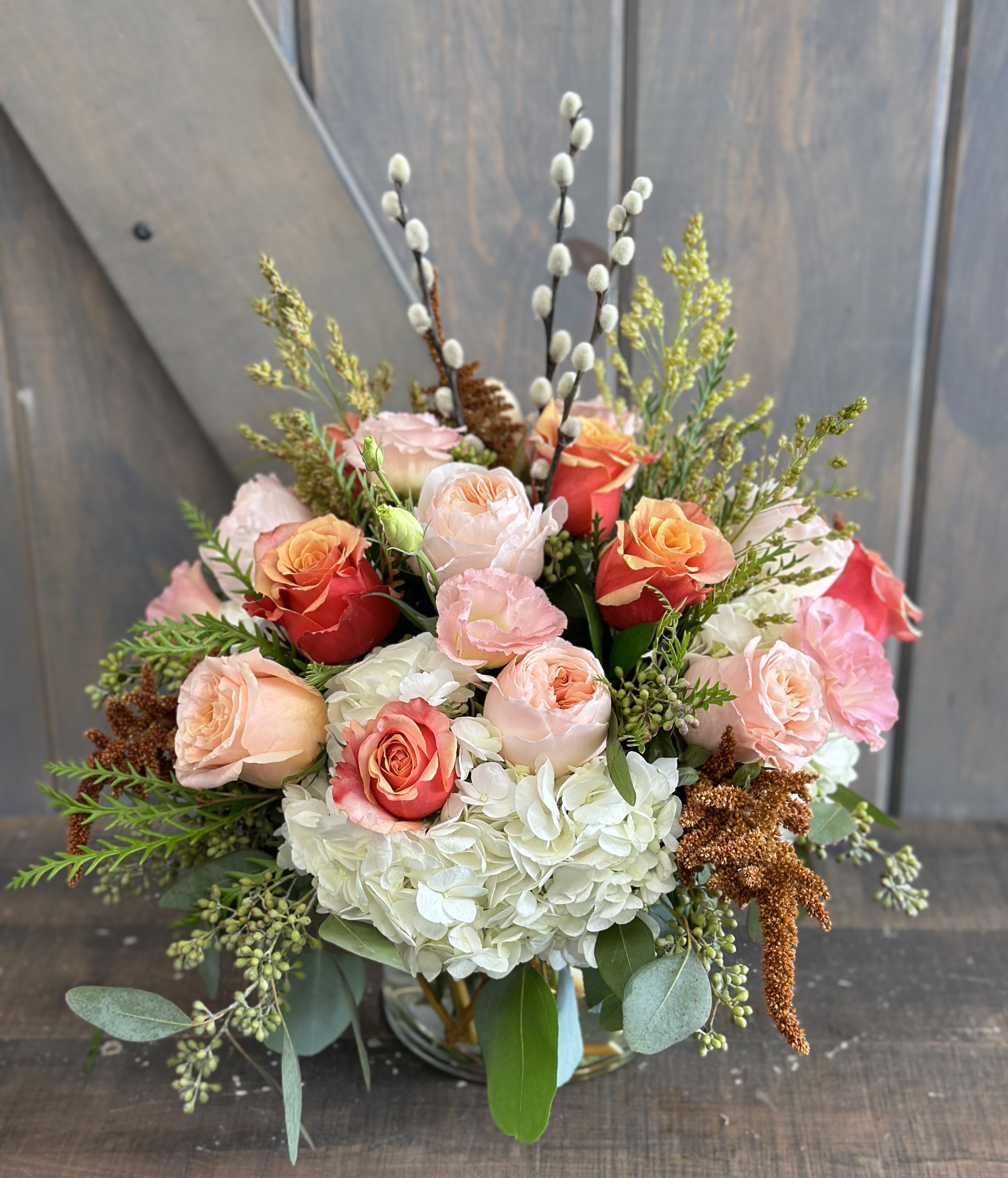 Autumn Shimmer - A Autumn take on one of our most popular arrangement &quot;Shimmer&quot;. Flowers included are Juliet Garden Rose, Rose, Lisianthius, Hydrangea, Pussy Willow, Hanging amaranthus, seeded euc, and broom corn.