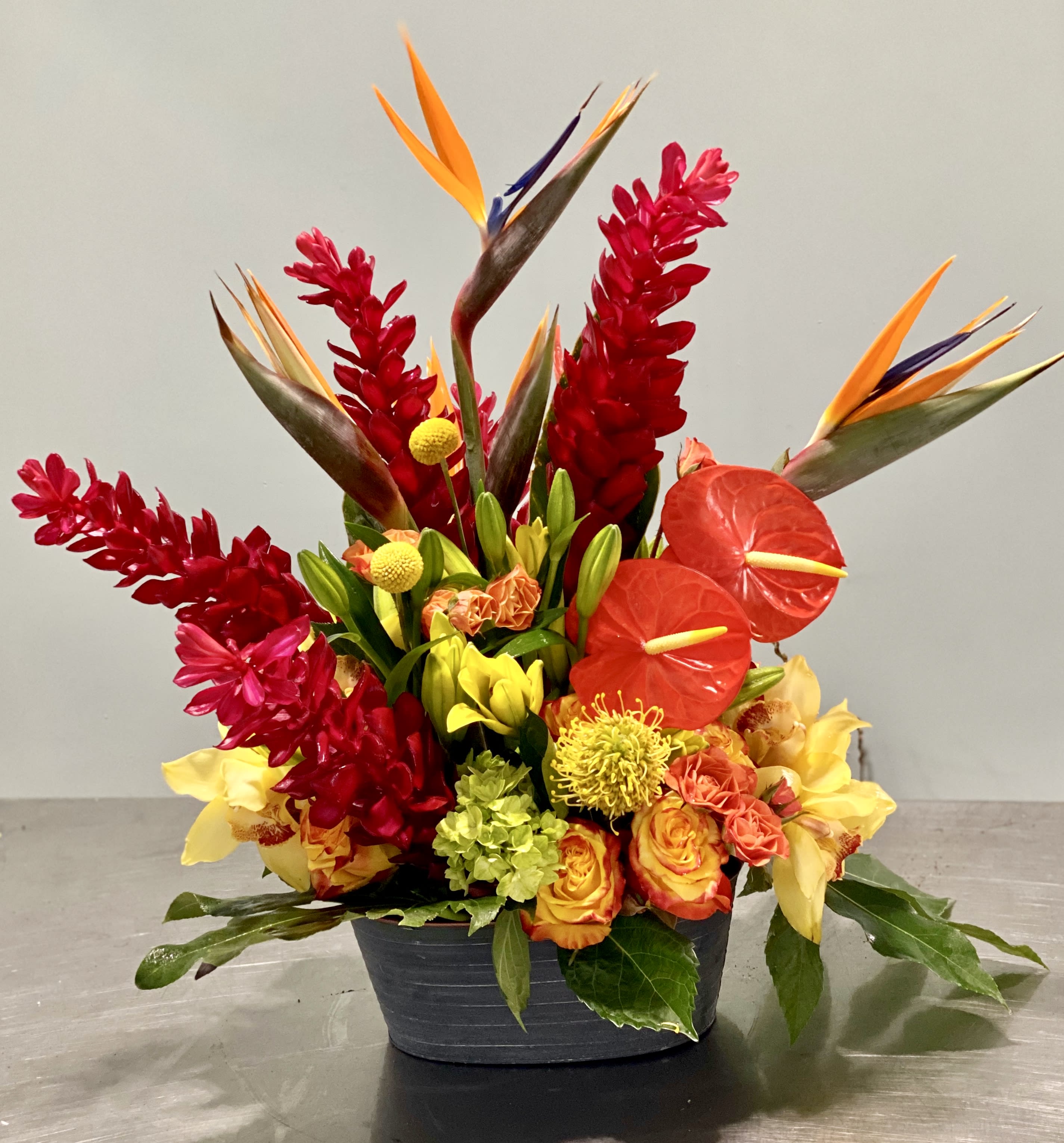 Tropical Samba - When it comes to celebrations or remembrances of joyful achievements and happy times, there is no better way to express it than with the vibrant colours of our tropical flowers.  Choose between the blends of red, yellow, greens, or f hot pinks, orange and greens, these colour can make your heart vibrate with joy. Based on availability. Pictured is our Deluxe option. Your personalized card is always handwritten and always free with Art Le Fleur!