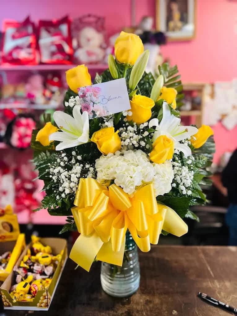 Yellow Arrangement  - 8 Yellow roses arrangement in a glass vase Green and white filler flowers 