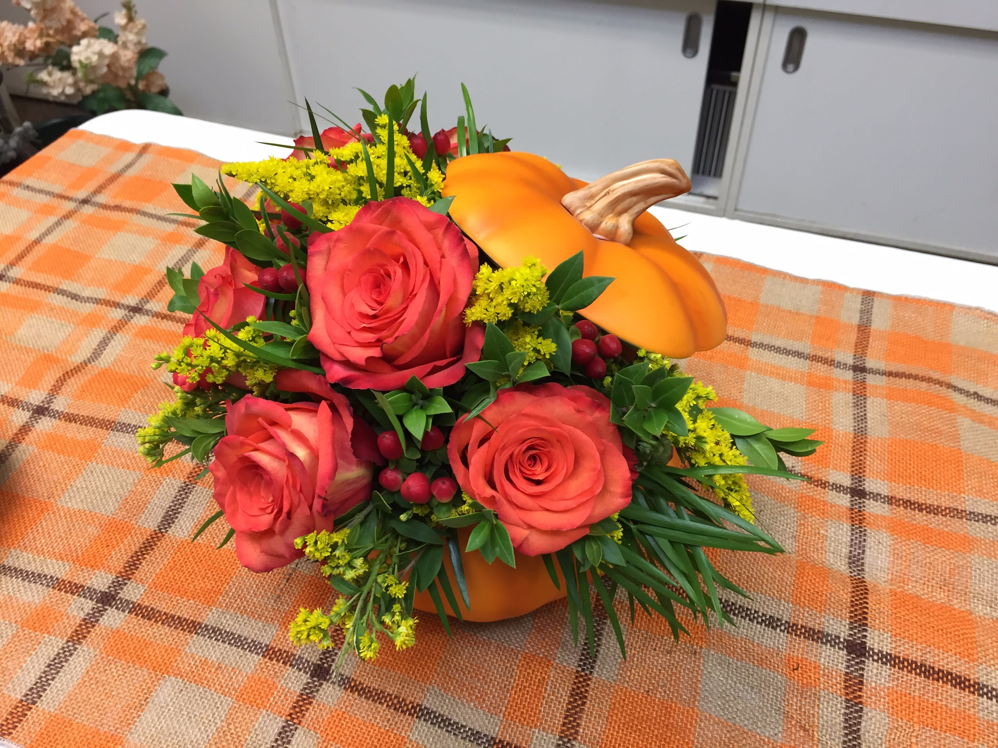 Fall Pumpkin Centerpiece - Fall color roses and mixed seasonal blossoms in a keepsake ceramic pumpkin. Limited inventory on pumpkin container. Actual arrangement varies daily.