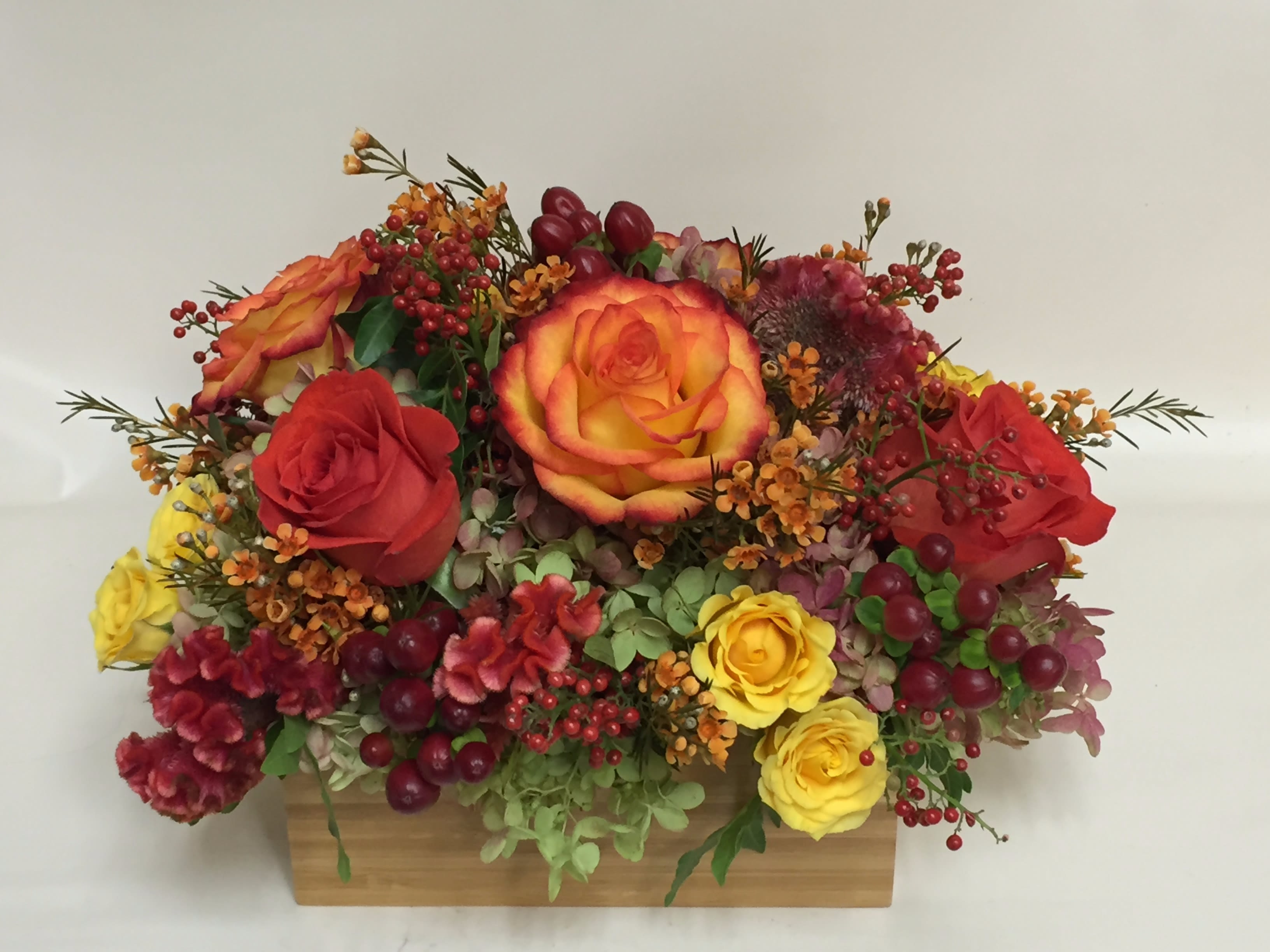Pelham Manor's Fall Bright - Mixed bright fall colors - yellow, orange, and ruby with a touch of sage green. Standard comes in 4&quot; cube. Deluxe and Premium may be designed as oblong centerpieces (shown in photo).