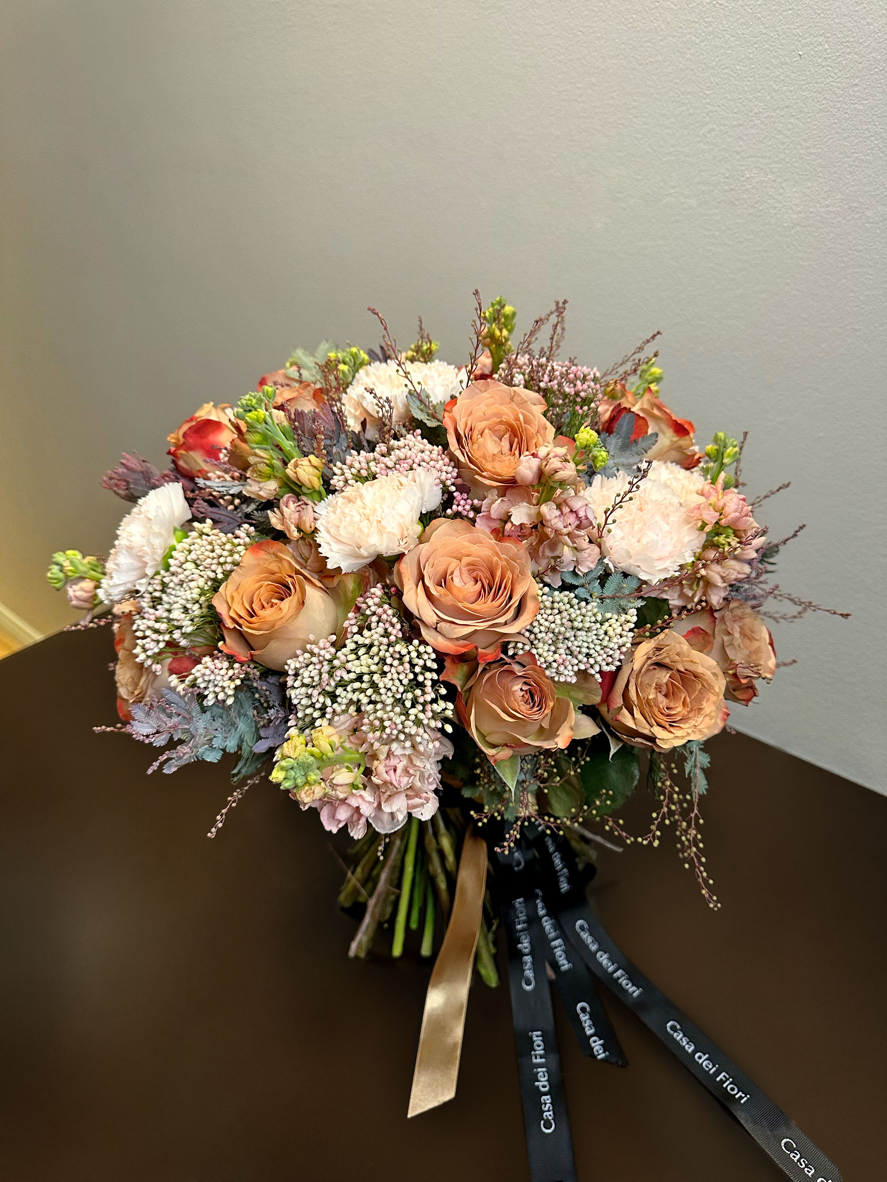 Caramel Kiss - A romantic bouquet of warm caramel-toned roses paired with delicate seasonal flowers and airy accents. This arrangement blends tenderness and elegance, making it a perfect gift to express affection and create unforgettable moments. Type of flower: Roses (17 stems), Dianthus, Matthiola, Waxflower, Decorative greenery and dried elements. 