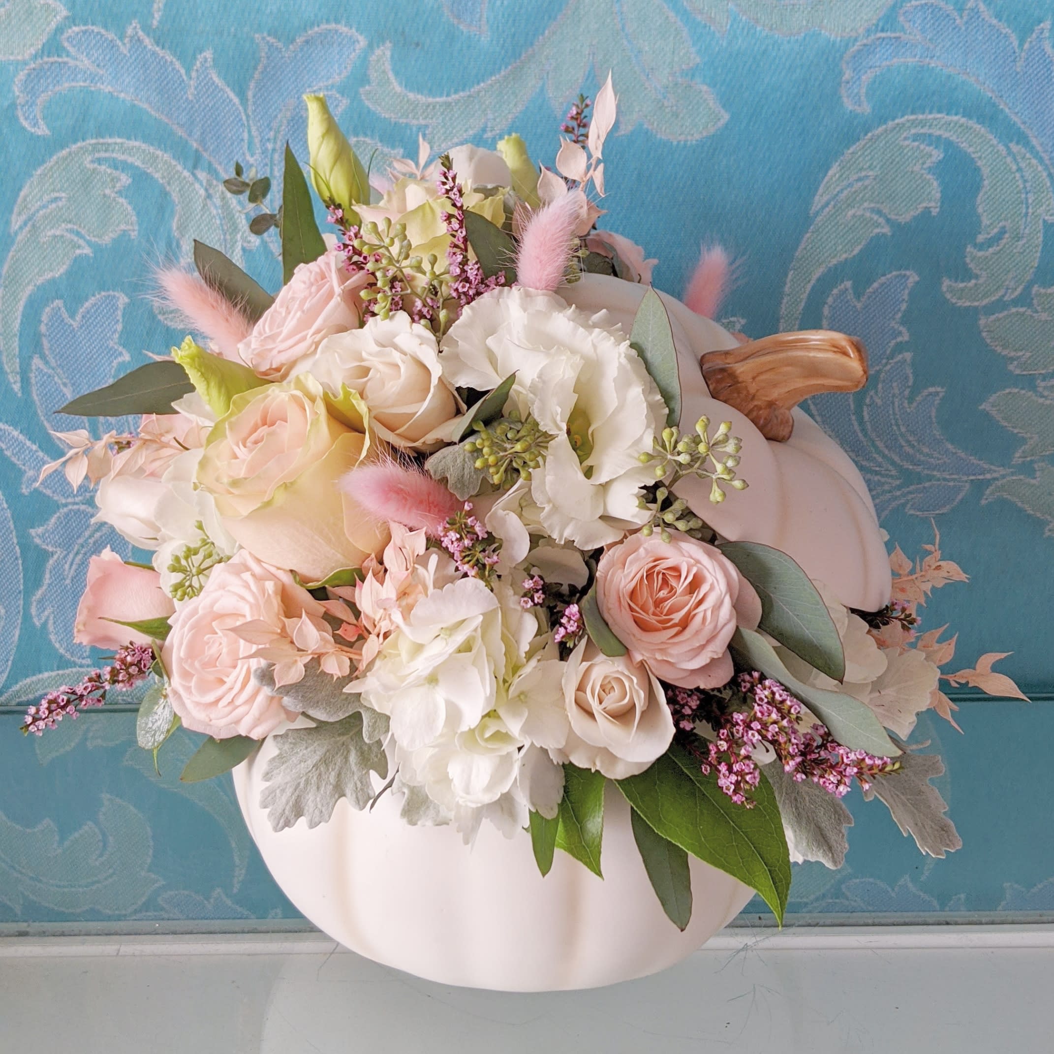 Shabby Chic Pumpkin - White ceramic pumpkin with a gentle mix of blush pinks and white roses, baby roses, hydrangea,  lisianthus, eucalyptus and dried Italian ruscus, bunny's tail, and pink pampas. This can come in any color combination if requested.
