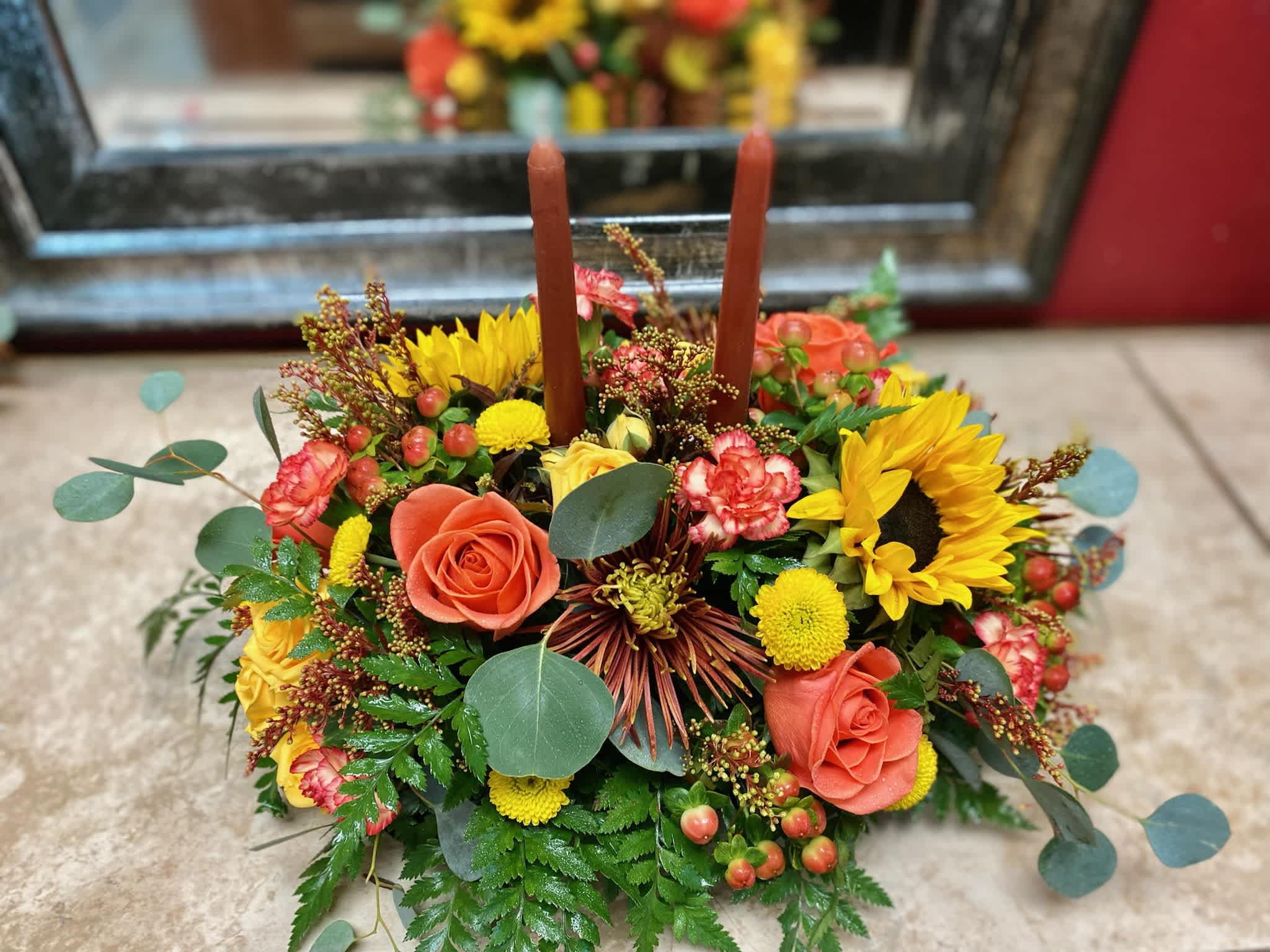 Happy Harvest Centerpeice Happy Harvest Centerpeice - Adorn your holiday table with this seasonal mix of fall flowers and colors with a candle ready for your holiday feast! Just to let you know, flowers and vases may vary but we do our best to match the arrangement shown.