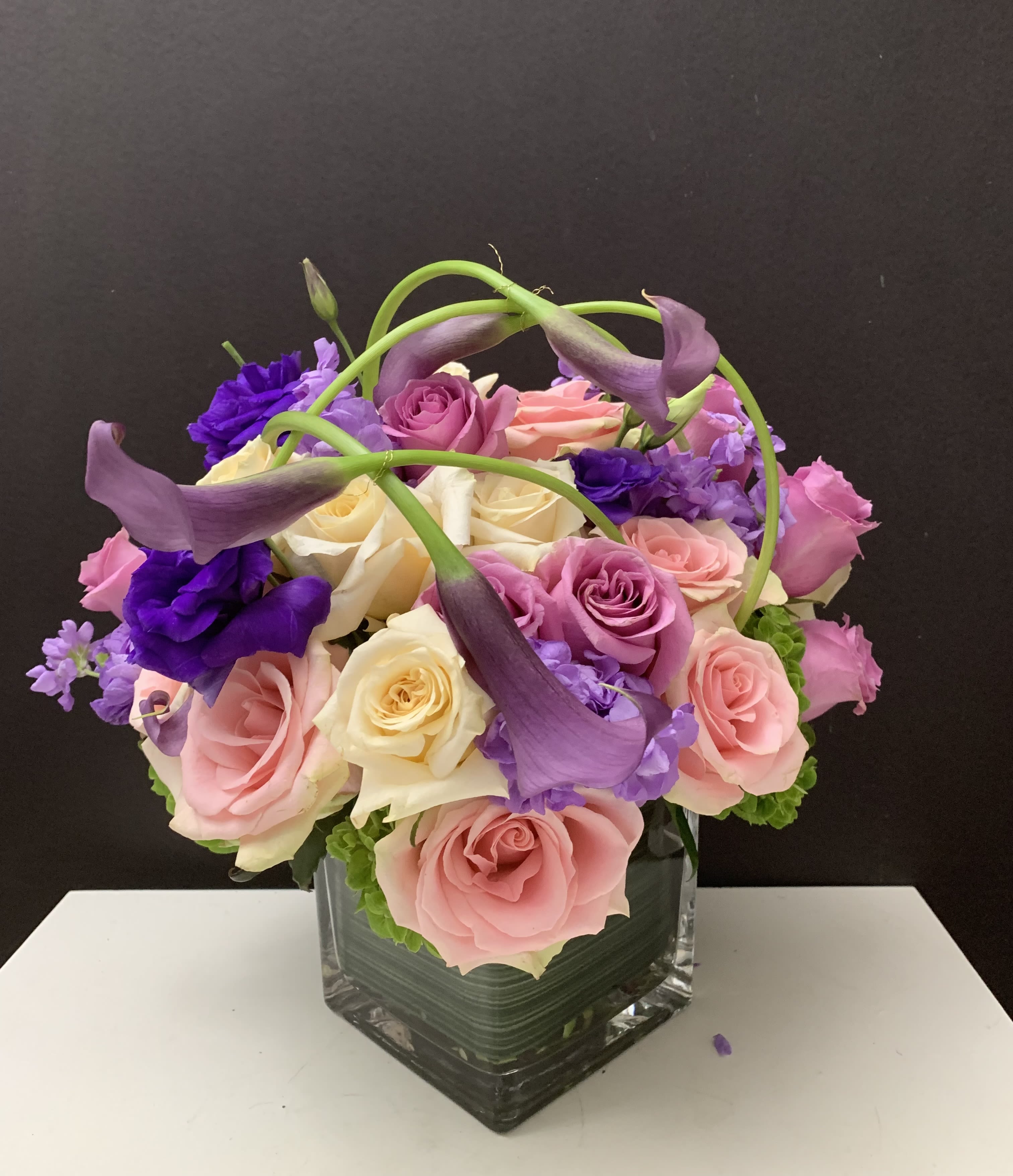 Assorted Blooms in a Square  - Roses, Mini Callas, Stock in a glass square 6”x 6” vase 