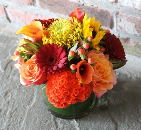 Autumn Breeze - A beautiful blend of warm-toned, fall blooms arranged in a vase with greenery.