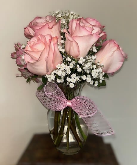 Ballet of Blooms - A delicate performance of blush pink roses  and airy baby’s breath, Ballet of Blooms pirouettes with grace and tenderness. Tied with a soft pink ribbon, this arrangement captures the poetry of petals in motion—an ode to beauty, balance, and heartfelt expression. 