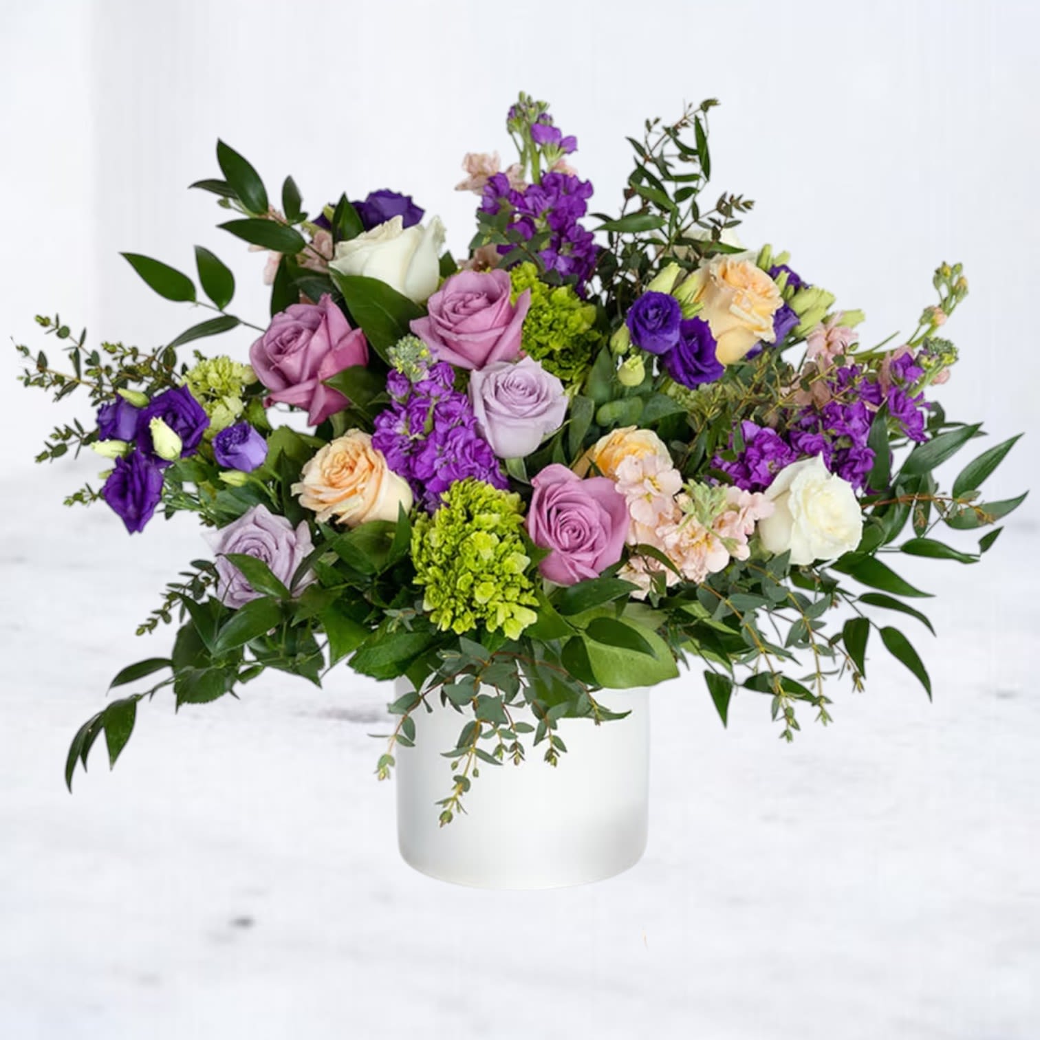 Dusktide Dusktide - Dusktide is a graceful floral arrangement created to honor life with quiet beauty and depth. Designed in a matte white container, it features a thoughtfully curated blend of lavender, mauve, and peach roses, purple lisianthus, stock, green hydrangea, and lush seasonal greenery, offering texture, movement, and gentle color transitions. Ideal for funeral services, memorials, or as a sympathy gift delivered to a loved one’s home. Its tone is refined and serene, a soft reflection of love, remembrance, and peace. Same-day flower delivery available in Houston, TX, Willis, Plantersville, Magnolia, Montgomery, Porter and Spring
