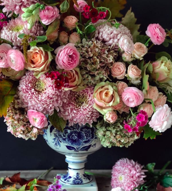 Chinoiserie - An ode to classic European floral artistry, this lush arrangement overflows with garden roses, ranunculus, chrysanthemums, and antique hydrangea in soft blush and vintage rose tones. Arranged in a timeless blue-and-white vessel reminiscent of fine Delftware, it evokes the charm of an heirloom painting brought to life. Each bloom whispers of romance, nostalgia, and the kind of beauty that lingers long after the moment has passed. A signature piece for the true floral connoisseur.