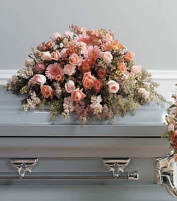 SF83-11 Casket Spray SF83-11 Casket Spray - A casket spray featuring a soft blend of coral, peach, and light pink blooms and arranged with fresh mixed greenery.
