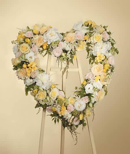 SF106-11 Heart Wreath SF106-11 Heart Wreath - A hanging heart wreath featuring a soft blend of whites, yellows and fresh mixed greenery. Stands are included with all wreaths and standing sprays.