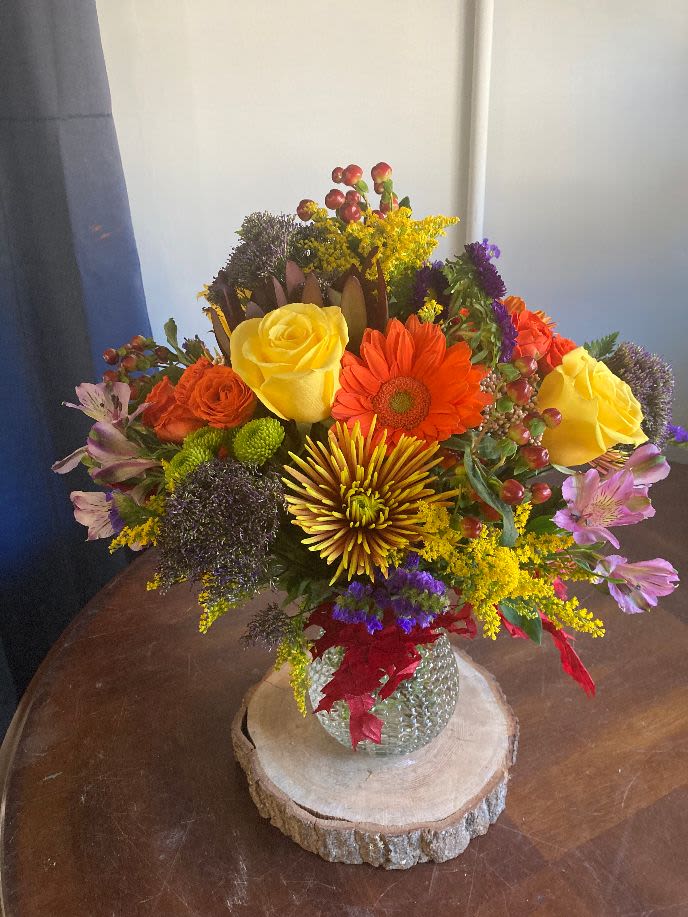 fall air - this medium sized arrangement is filled with fall flowers in a unique bubbled glass vase