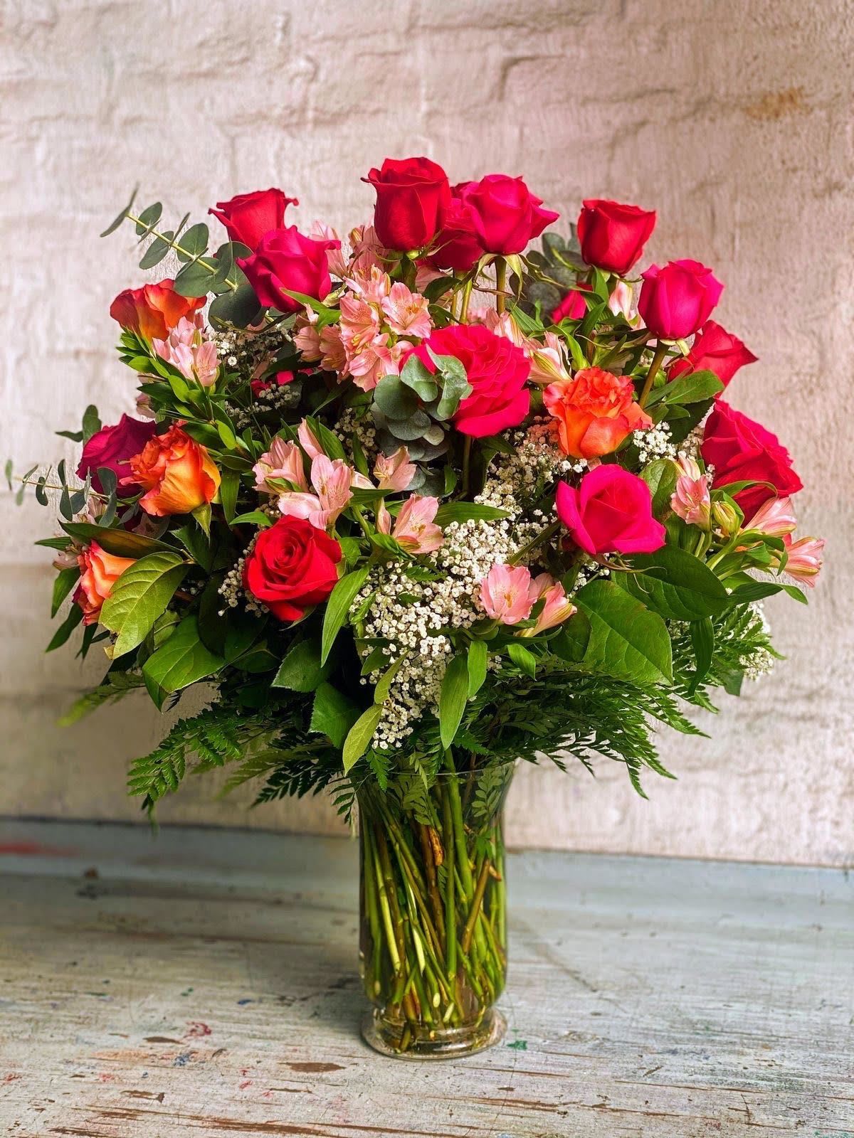 Radiant Rose Garden Bouquet  - Make any moment unforgettable with our Radiant Rose Garden arrangement. This stunning bouquet bursts with vibrant red roses, fiery orange blooms, soft pink alstroemeria, and delicate white accents, all elegantly arranged in a clear glass vase with lush greenery. Perfect for birthdays, anniversaries, or simply to brighten someone’s day, this bouquet is a timeless expression of love, joy, and beauty.