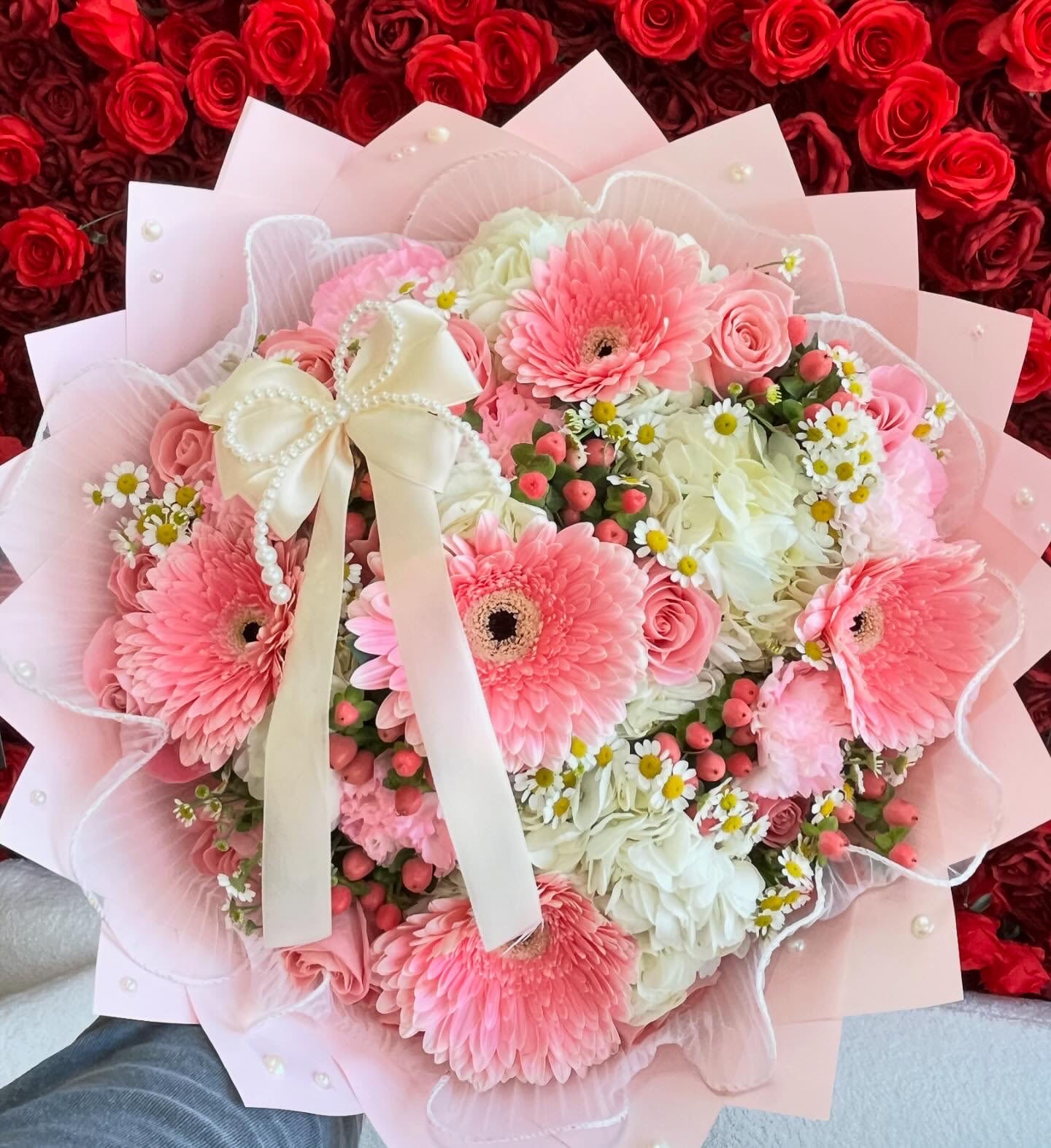 Coquette Bloom Bouquet - This stunning arrangement features lush white hydrangeas, cheerful pink Gerber daisies, delicate chamomile blooms, vibrant Hypericum berries, and soft pink carnations. Wrapped in elegant pink paper adorned with pearls and finished with a charming bow on top, this bouquet is perfect for celebrating life’s sweetest moments