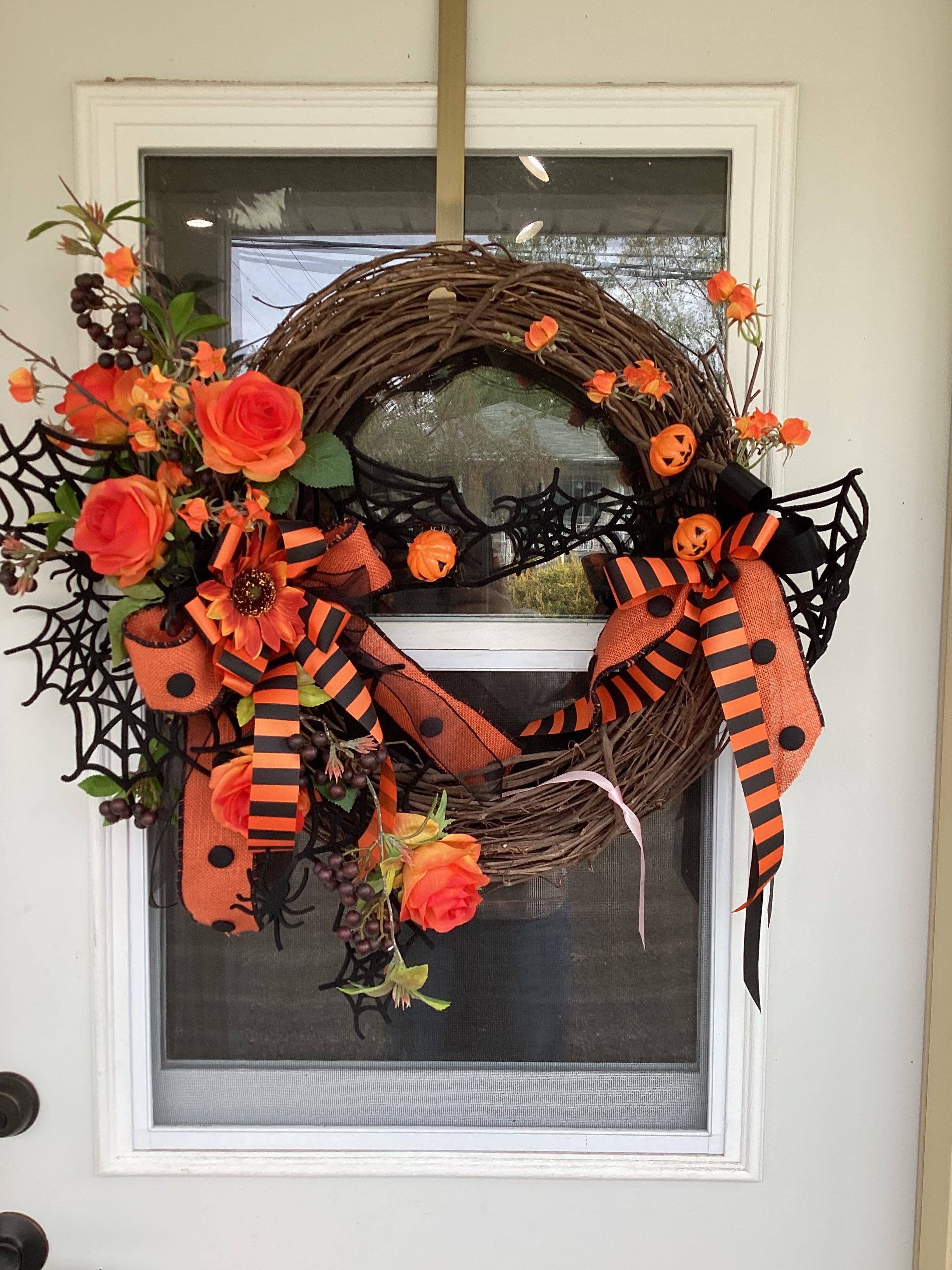 Orange Halloween Wreath - A wreath decorated with Halloween ribbon, orange silks, and jack-o-lanterns
