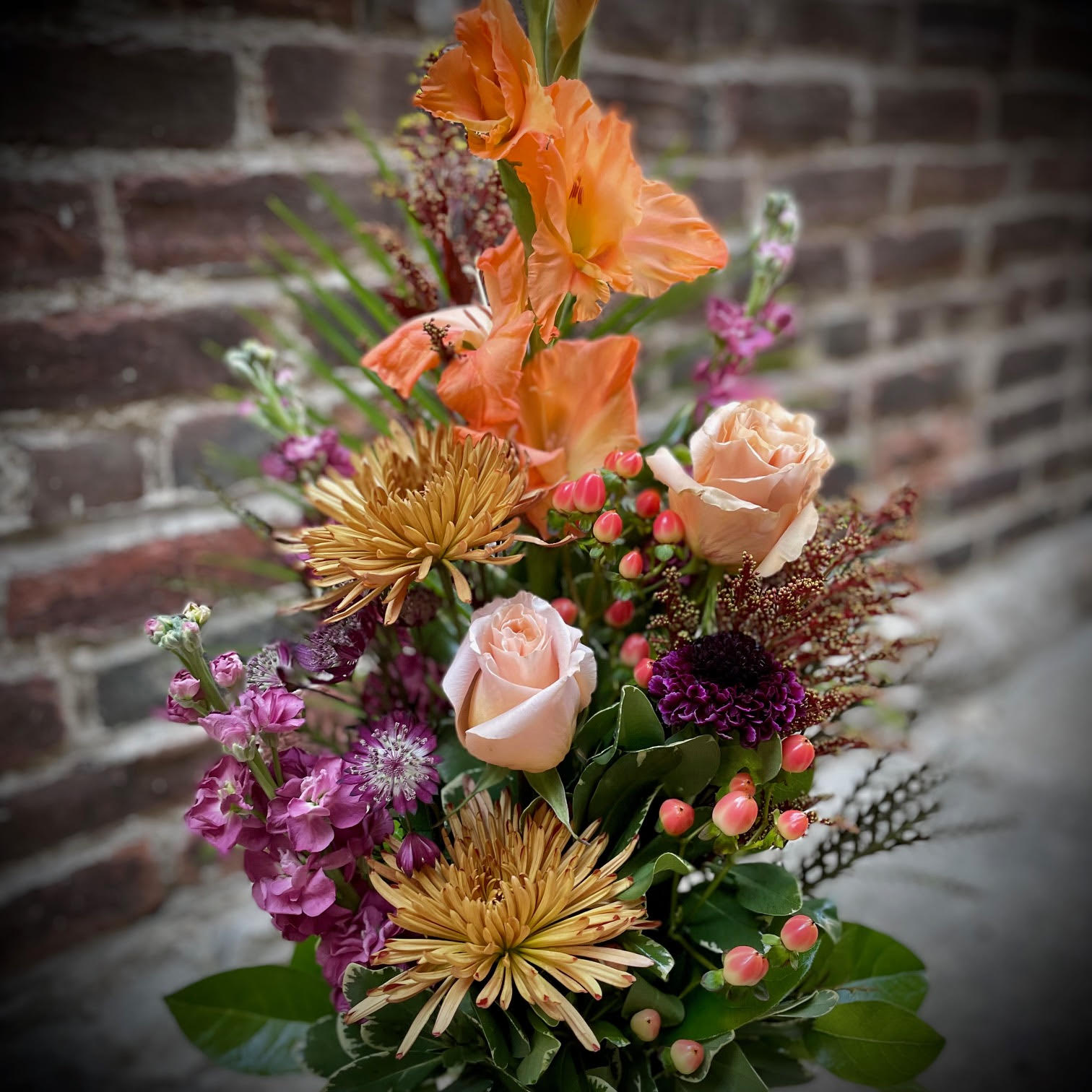 Blissful Autumn - The Blissful Autumn is artfully arranged with roses, spider mums, stock, gladiolas, Astrantia, Scabiosa, and berries, in an array of orange, peach and dusty pink. This arrangement is perfect to bring the stunning colors of fall into any home or office space.