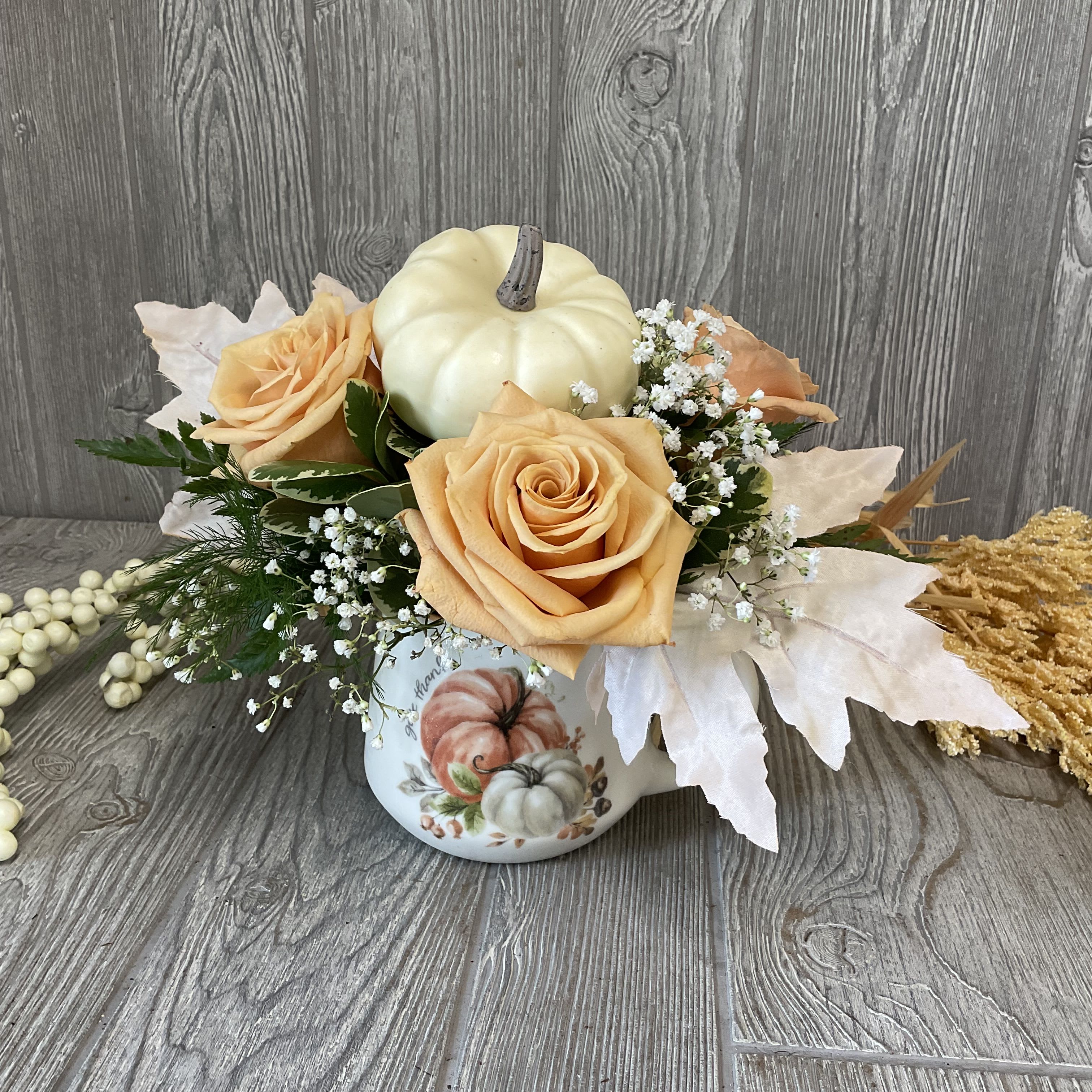 Give Thanks - Cute ceramic mug with a pumpkin design, filled with fall festive roses, filler, and a faux pumpkin.   Colors and flowers may vary.