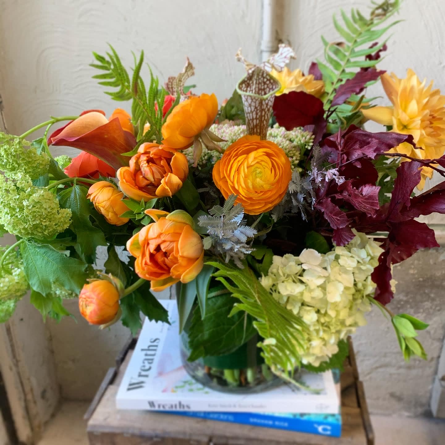 Autumn Harvest  - A collection of seasonal orange hues - calla lilies, ranunculus and  tulips suit this arrangement with autumnal foliages