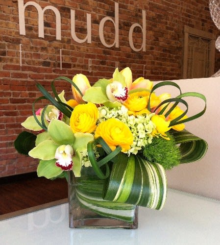 Petit Sexy Citrus Design - Green or yellow cymbidium orchids, green hydrangea, and dianthus detailed  here with golden ranunculus, and curled tropical foliage.  Delicious