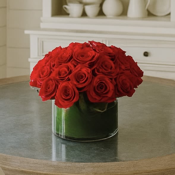 Love &amp; Devotion - Treat your family and friends to a beautiful display of love and devotion with these two dozen stunning red roses! This gorgeous arrangement comes in a clear cylinder low vase, adding a perfect touch of elegance and sophistication to any room. Every red rose is treated with care and love, providing the perfect way to show your affection. From a night's dinner setting to a special anniversary, these multiple roses will never fail to express how deeply you care. Nothing says true love and devotion like a dozen fresh red roses specifically chosen just for them! Speak from your heart and show your affection this season with Love and Devotion.