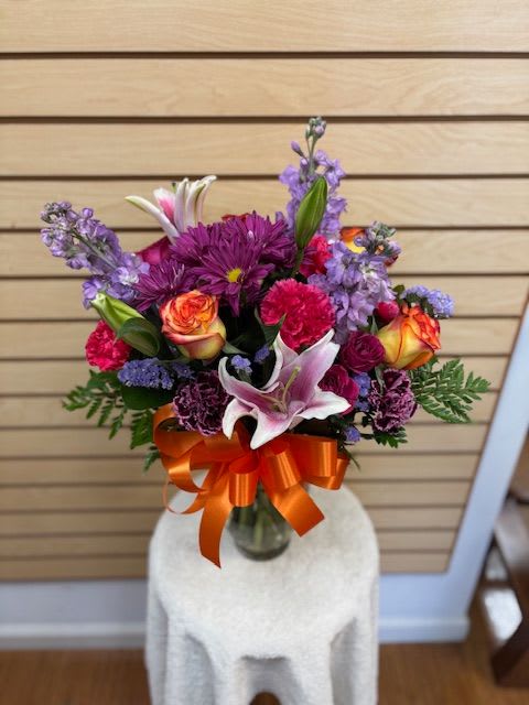 Vibrant Splash - Mixed cut with purple daisies, purple stock, high and magic roses, stargazer lily, hot pink carnations, and purple statice.