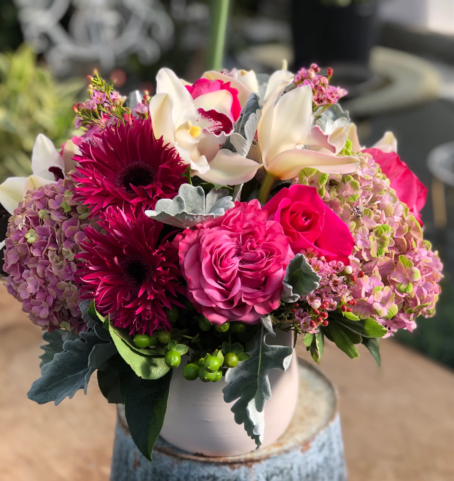 Mary - A stunning display of pink Gerbera daisies,  Pink Garden roses, pink Hydrangea, white Cymbidium orchids, green Hypericum berries , Dusty Miler and pink Wax Flower.