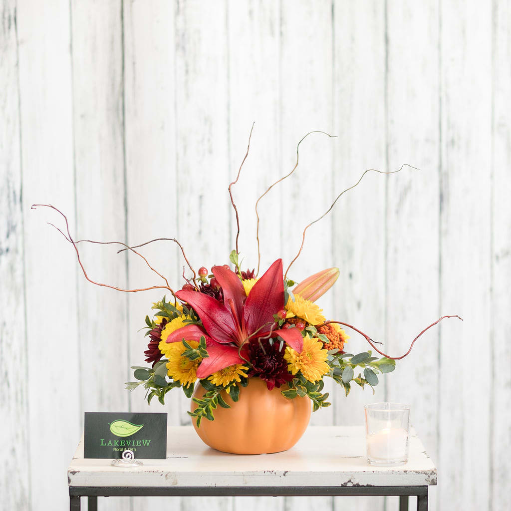 Pumpkin Pumpkin - A perfect combination for fall. Lilies, mums and curly willow fill this cute ceramic pumpkin container that can be used again and again.