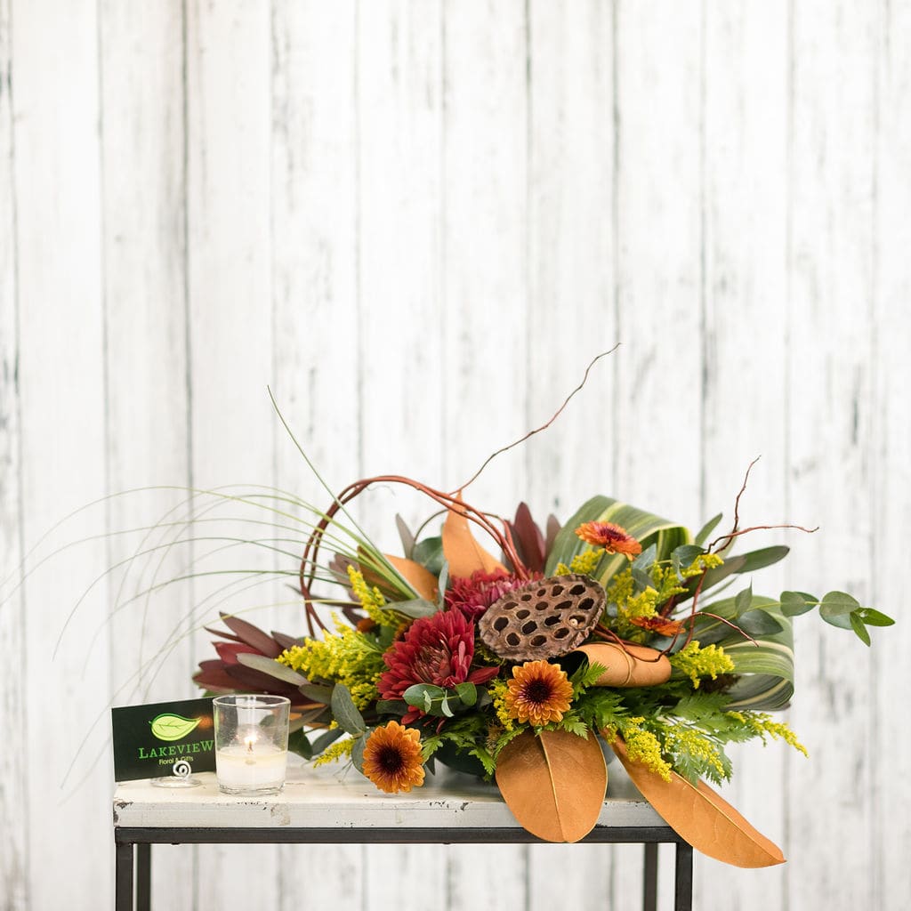 Toffee - Let this unique centerpiece take stage at your next get together with loops of curly willow, sprays of mums and a dynamic lotus pod.  