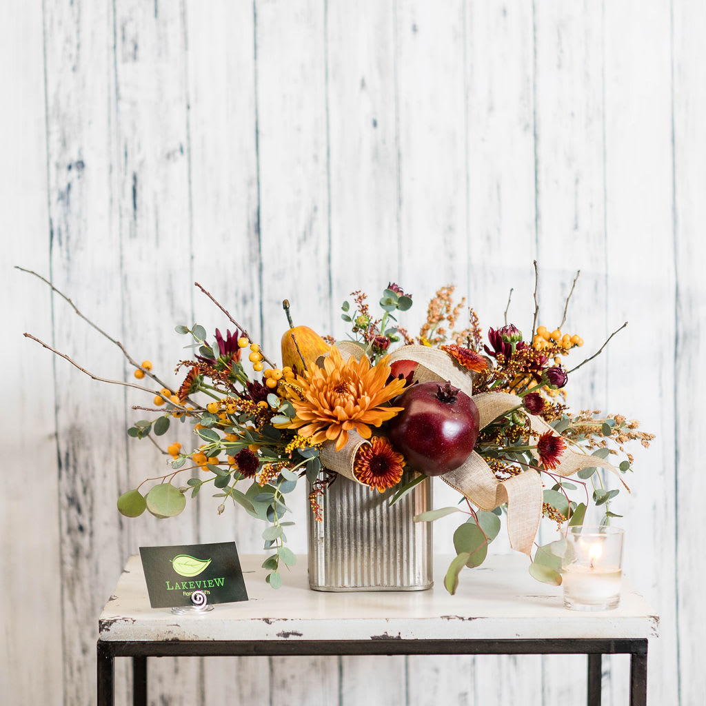 Feast - A delectable autumn centerpiece features faux fruit~ pear, pomegranate &amp; apple with fall favorite blooms in a rich, luxurious colors!  Have a large table?  Upgrade to premium for a larger centerpiece!  Approx.: 11&quot;H x 18&quot;W