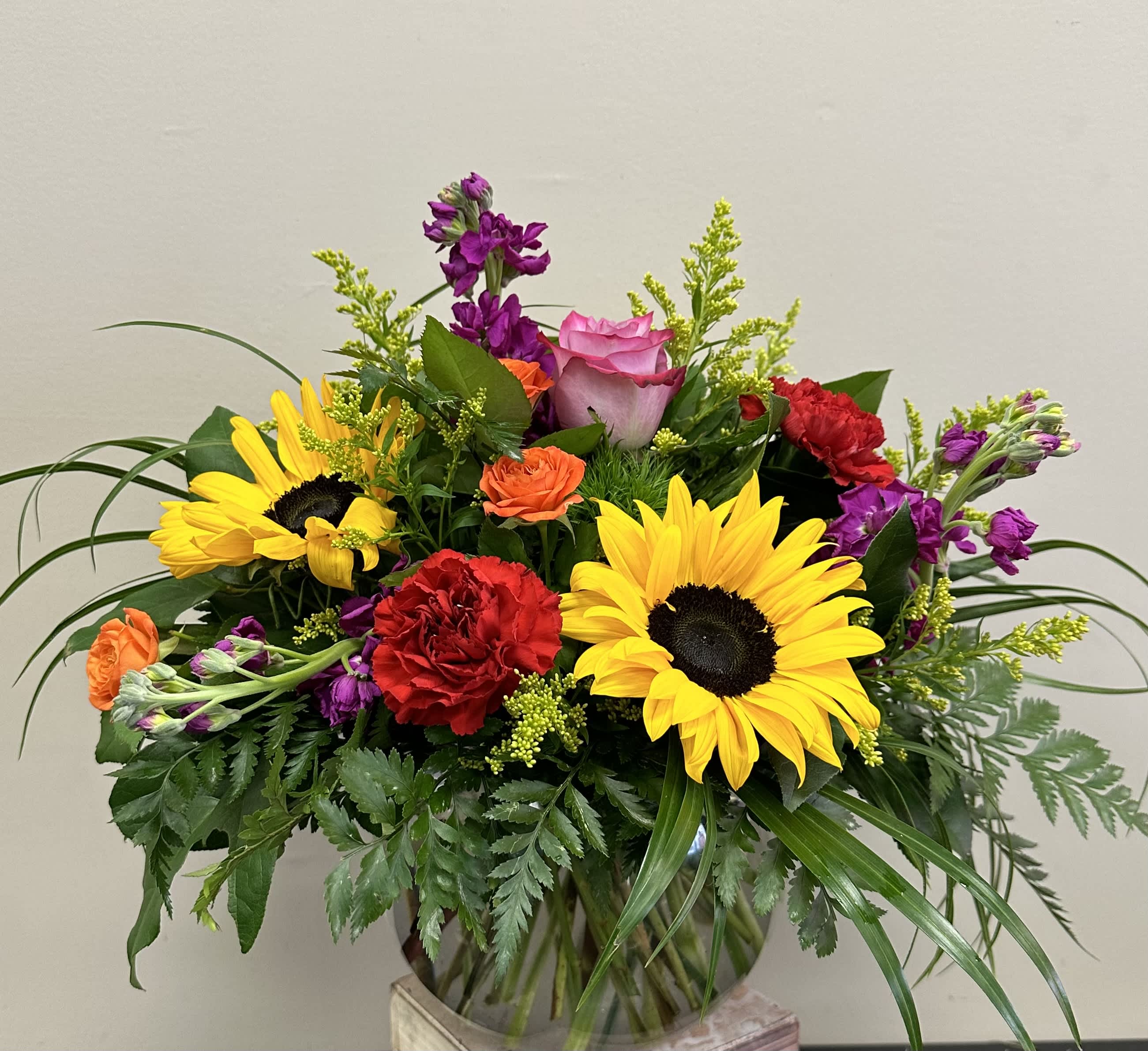 My Garden My Garden - This garden style arrangement includes sunflowers, roses, stock, and seasonal blooms. This is a great gift for a birthday or Just Because. APPROXIMATE DIMENSIONS: 12" D x 12" H
