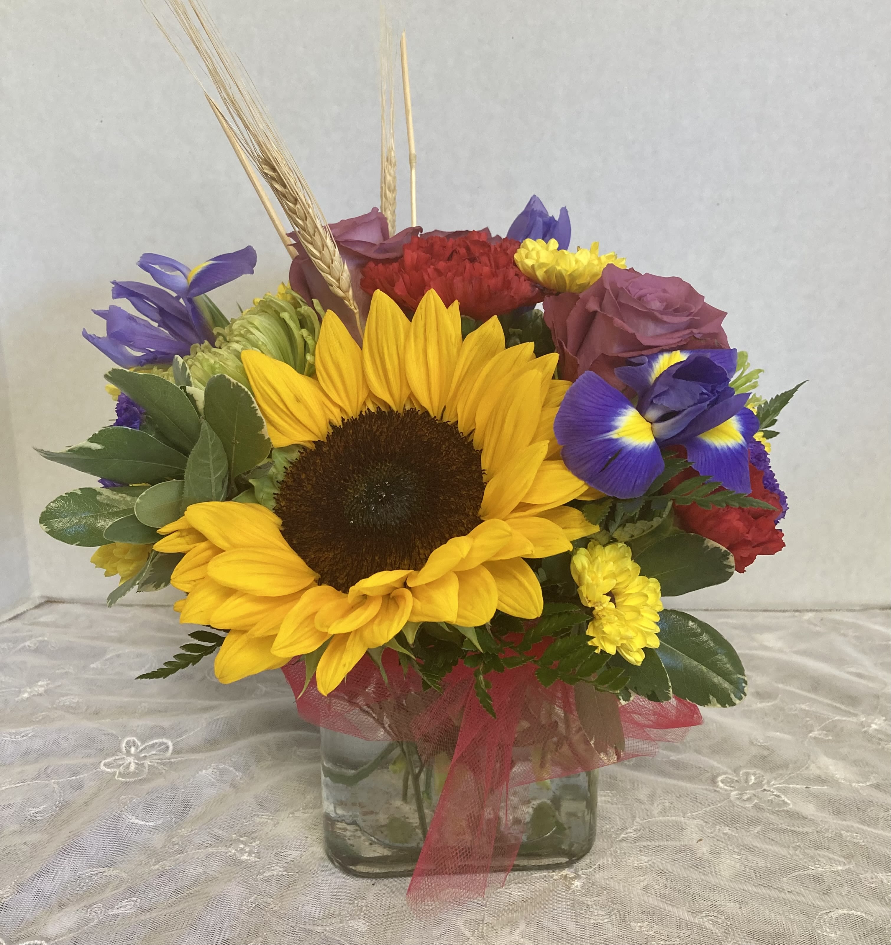 Hello Fall by Candlelight &amp; Roses - Low &amp; lush design with all the best of fall! Send some good cheer with bright sunflowers, iris, green spiders, lavender roses &amp; more. Works for many occasions.